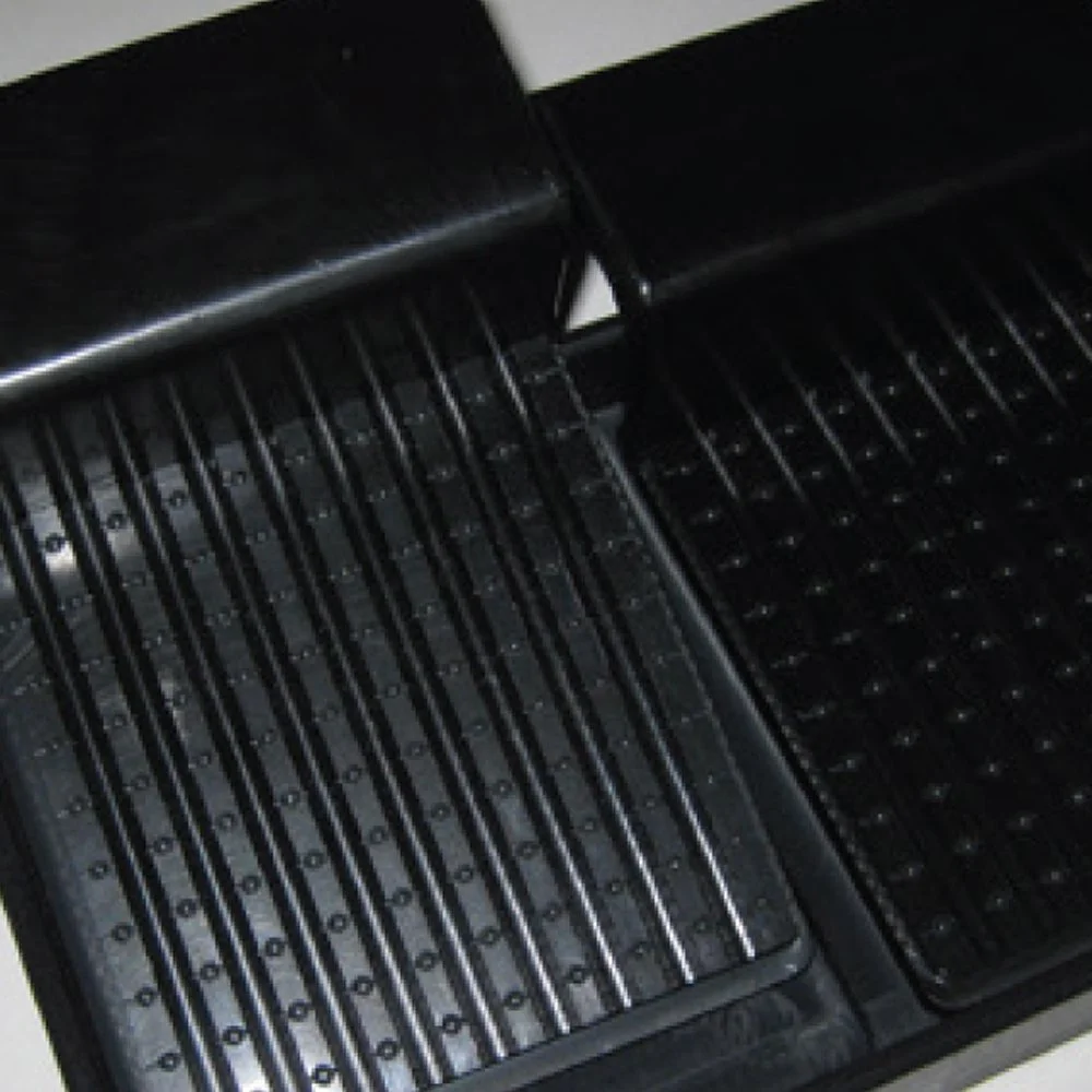Two black rubber truck bed mats with textured flooring, overlapping at the corners.