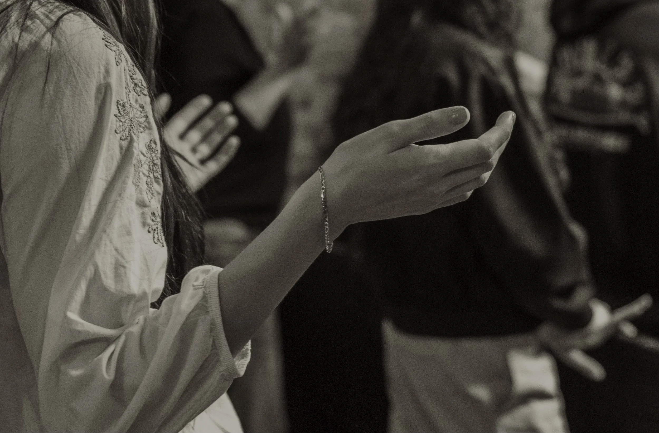 Close-up of a woman's hand holding a smartphone, with a row of shoes in the background.