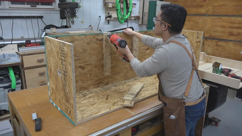 OSB strapping is glued and brad nailed to the inside of the welding jig structure to reference and locate the two middle cross-supports.
