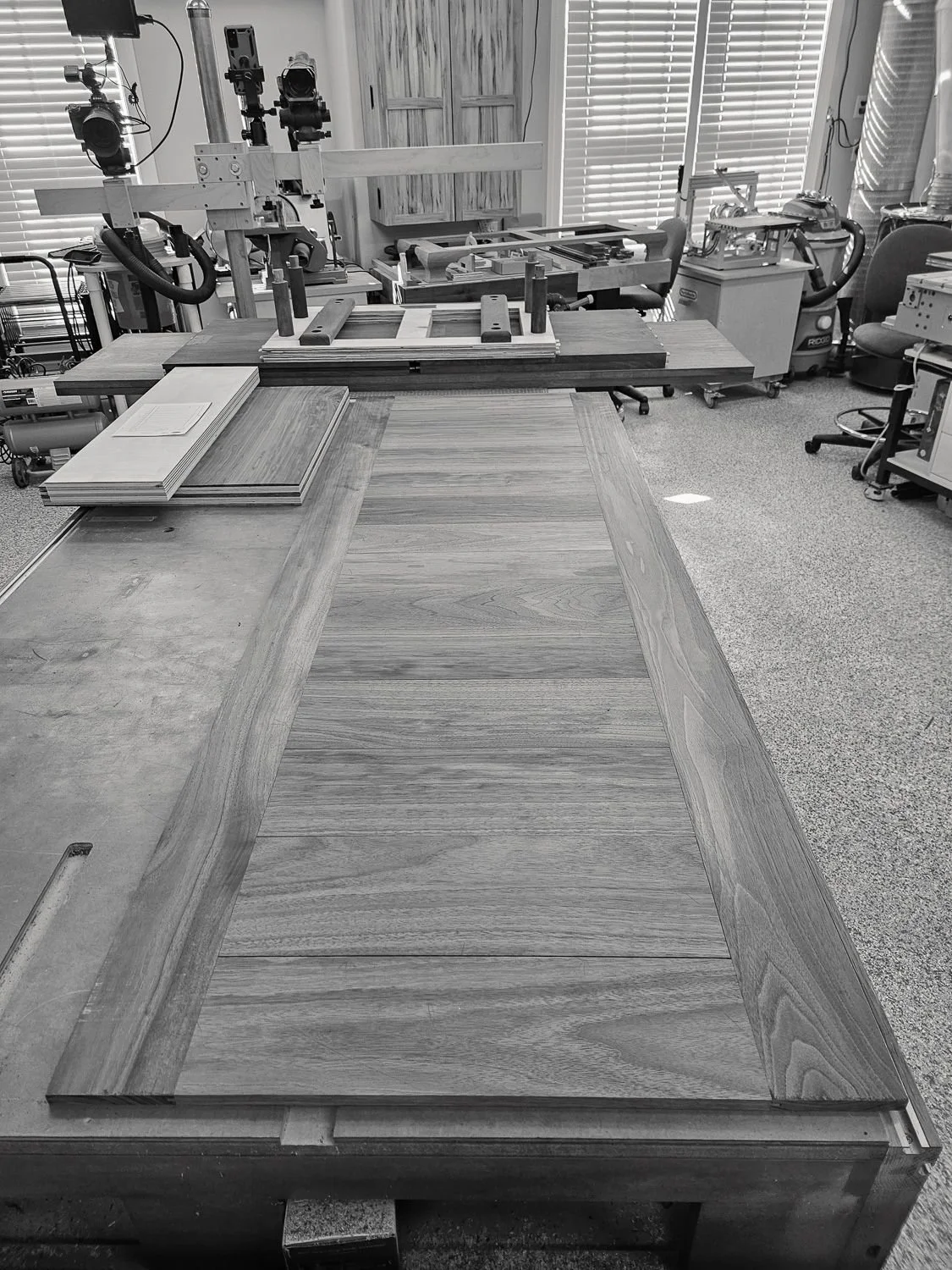 Large walnut panel laid out on a workbench in the workshop