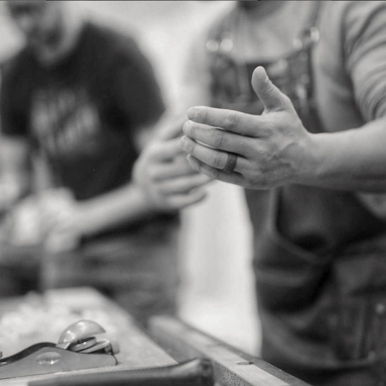 Close-up of a woodworking instructor gesturing while explaining a hand-tool technique.