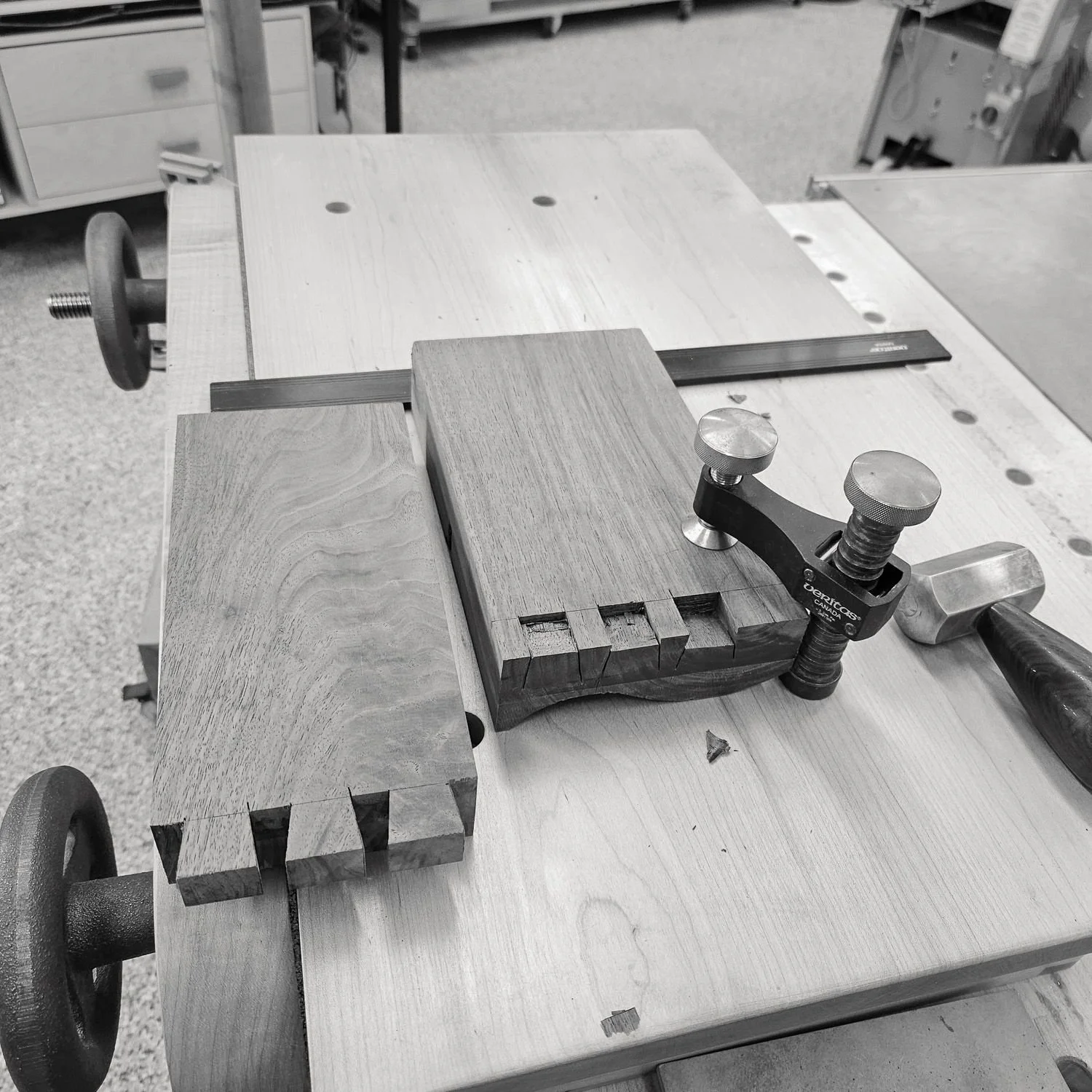 Hand-cut dovetail joints being fitted in walnut components during construction of the Masterworks china cabinet.