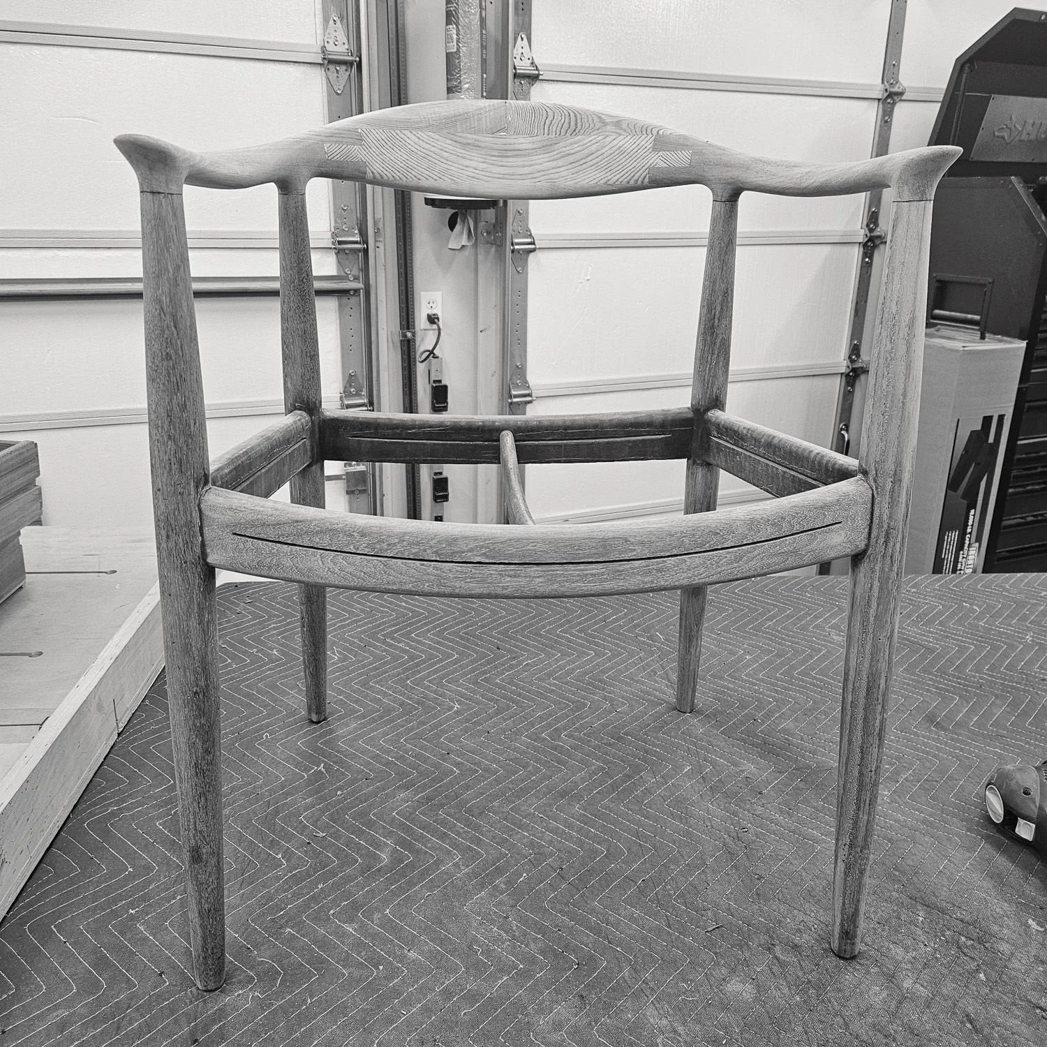 Front view of the Hans J. Wegner JH 503 teak chair frame in the workshop before upholstery.