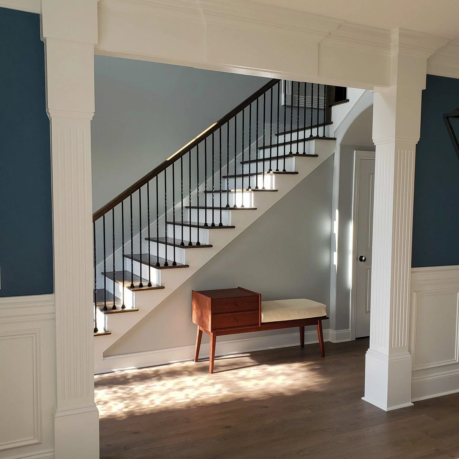Mid-Century Modern Sapele Gossip Bench viewed from an adjoining room beneath the staircase