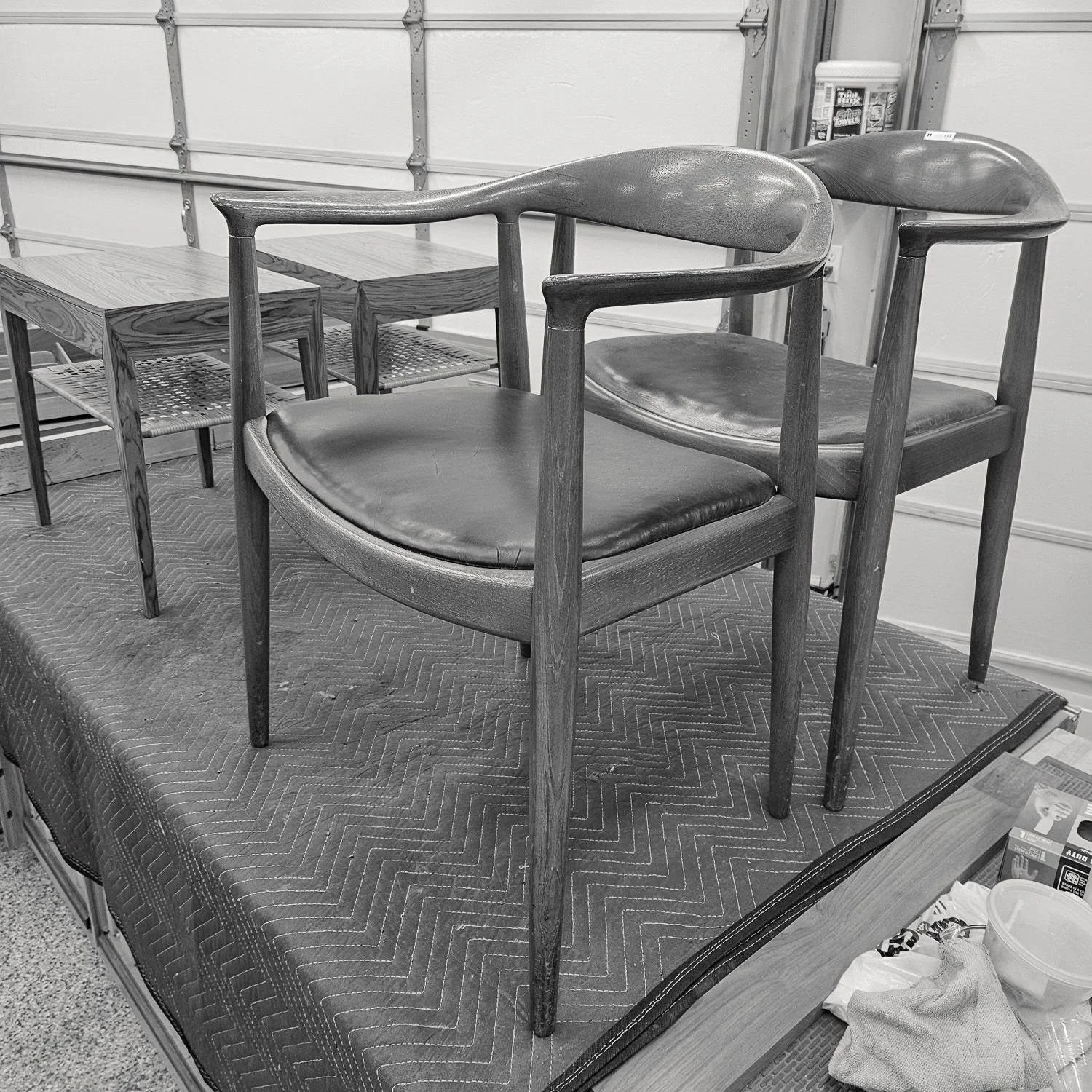 Two vintage lounge chairs in the workshop during furniture restoration