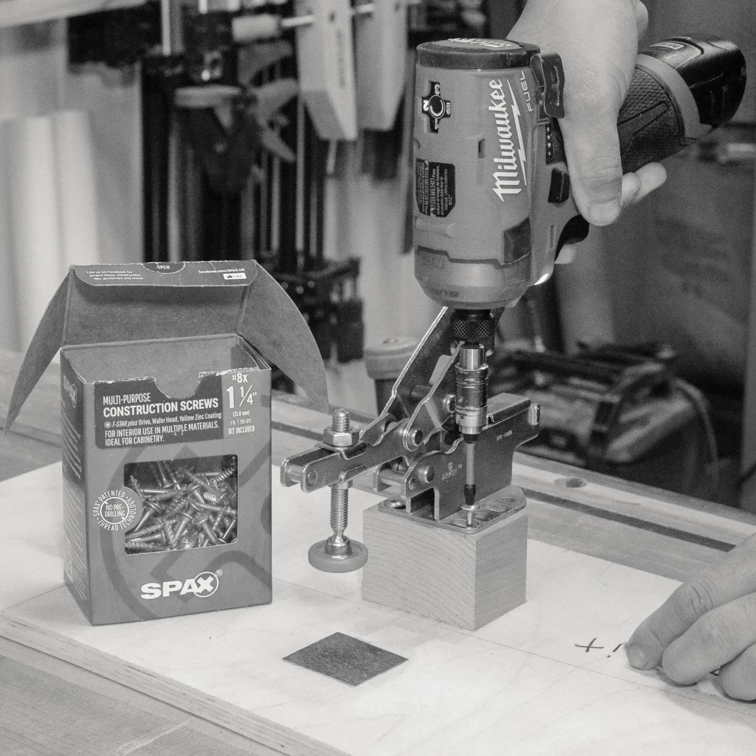 Milwaukee cordless impact driver being used to drive a screw into a woodworking jig.
