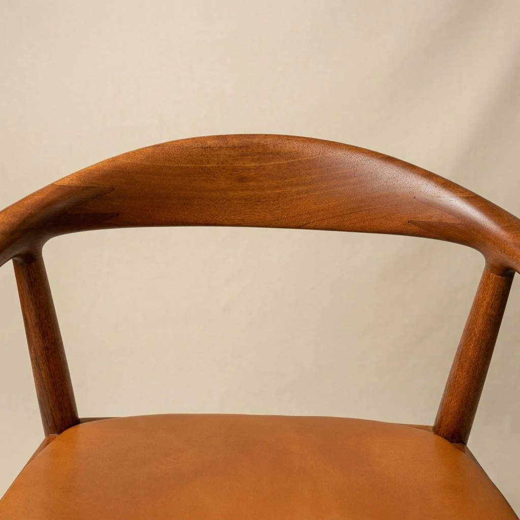 Close-up of the sculpted oak backrest and arm detail on the restored Hans J. Wegner JH 503 chair.