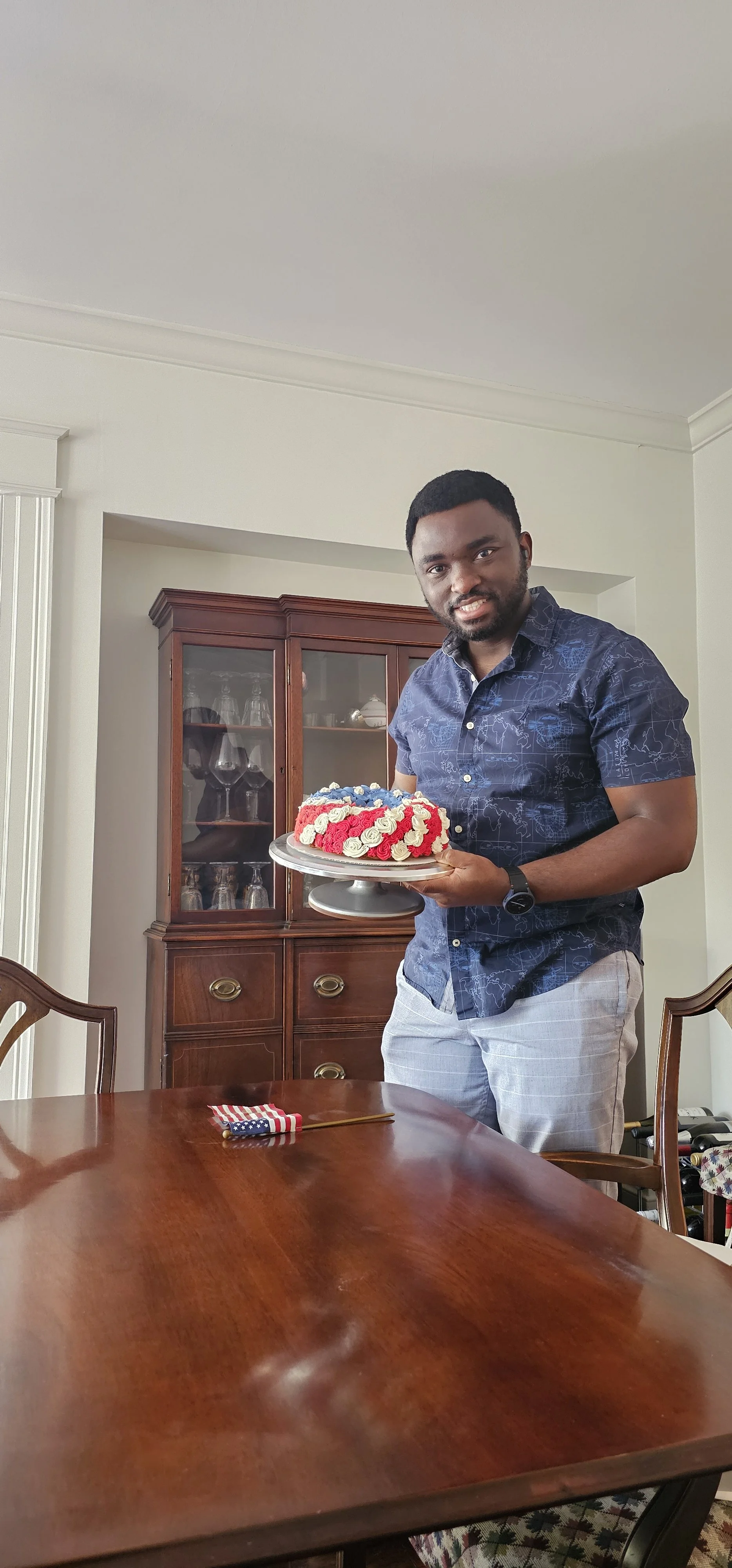 bakedbyAma baker holding a decorated celebration cake.