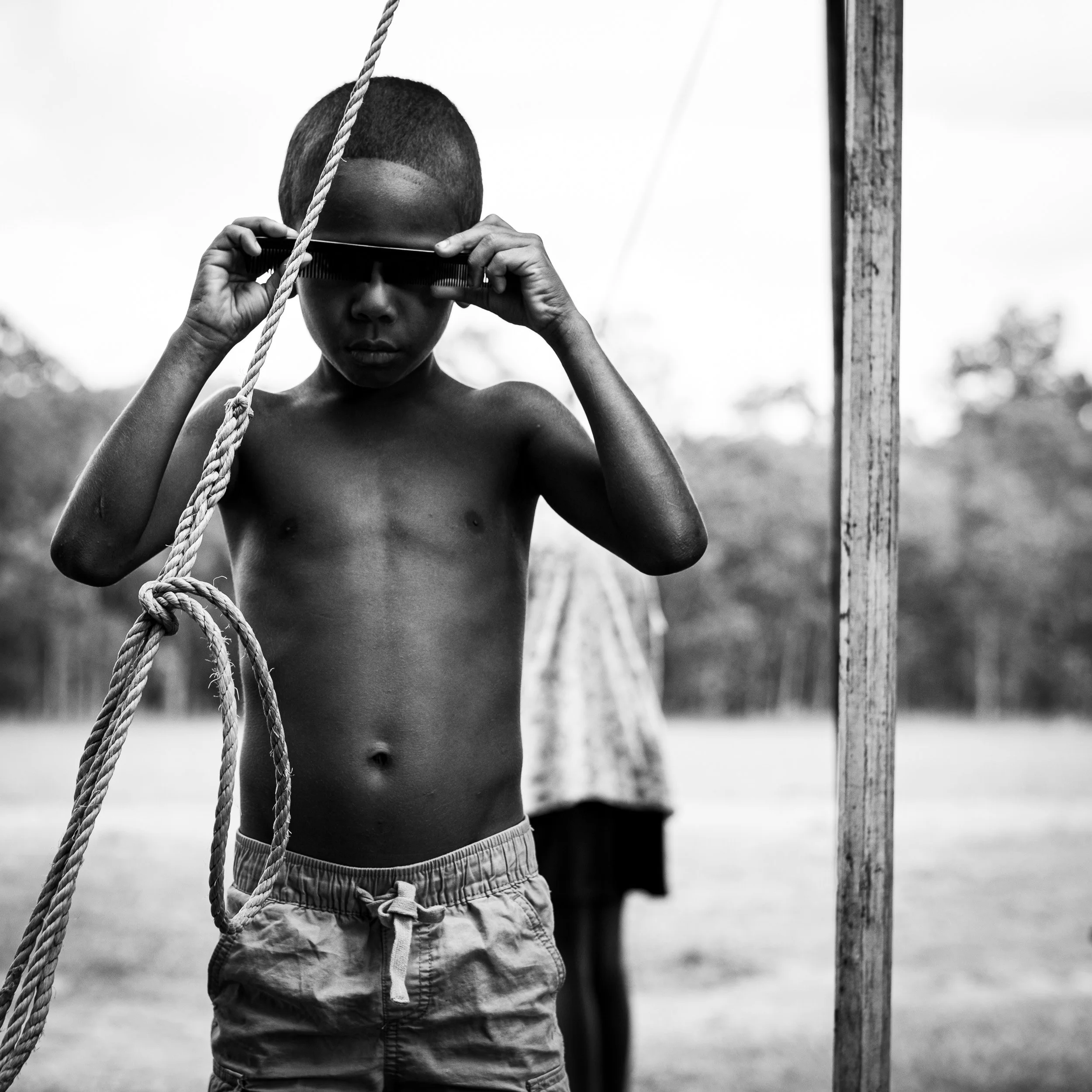 Black and white fine art portrait from From Land to Sea by Tommy (Thomas) Salpietro, depicting a young Kuku Yalanji child in Far North Queensland, Australia.