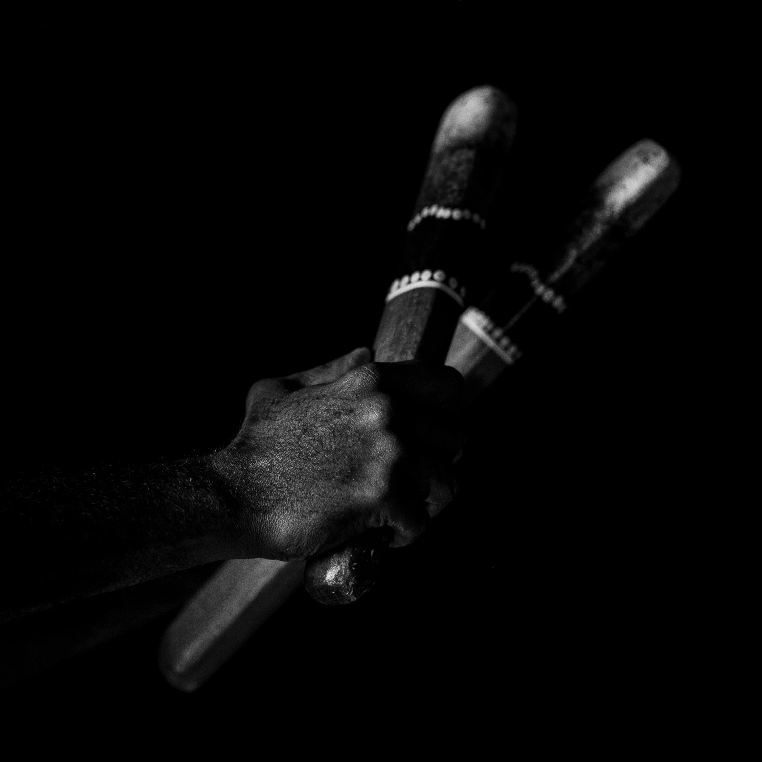 Black and white fine art photograph from From Land to Sea by Tommy (Thomas) Salpietro, depicting traditional Kuku Yalanji clapsticks in Far North Queensland, Australia.