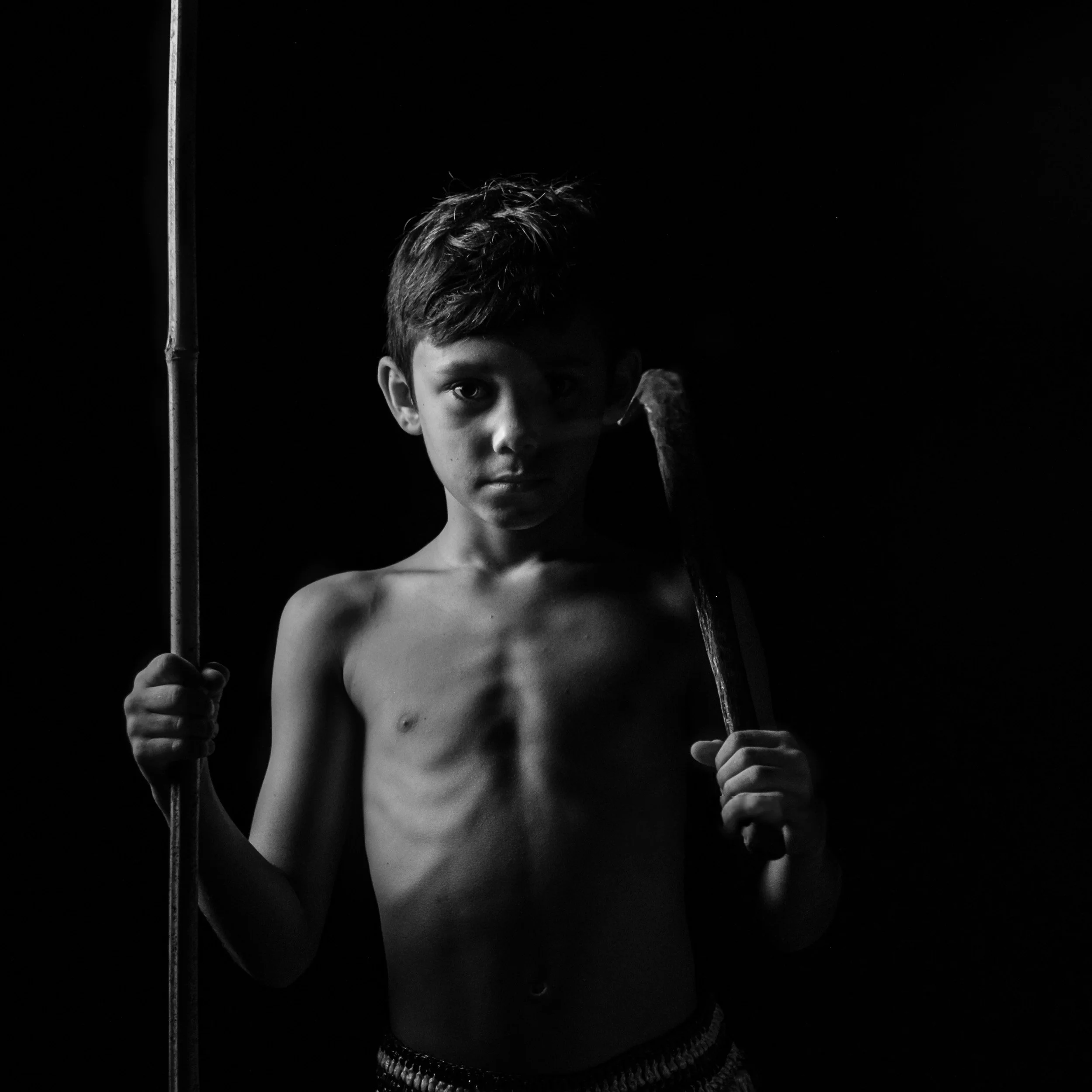 Black and white fine art portrait from From Land to Sea by Tommy (Thomas) Salpietro, depicting a young Kuku Yalanji community member. Documentary photography exploring Indigenous Australian culture, identity and the passing of knowledge between gener