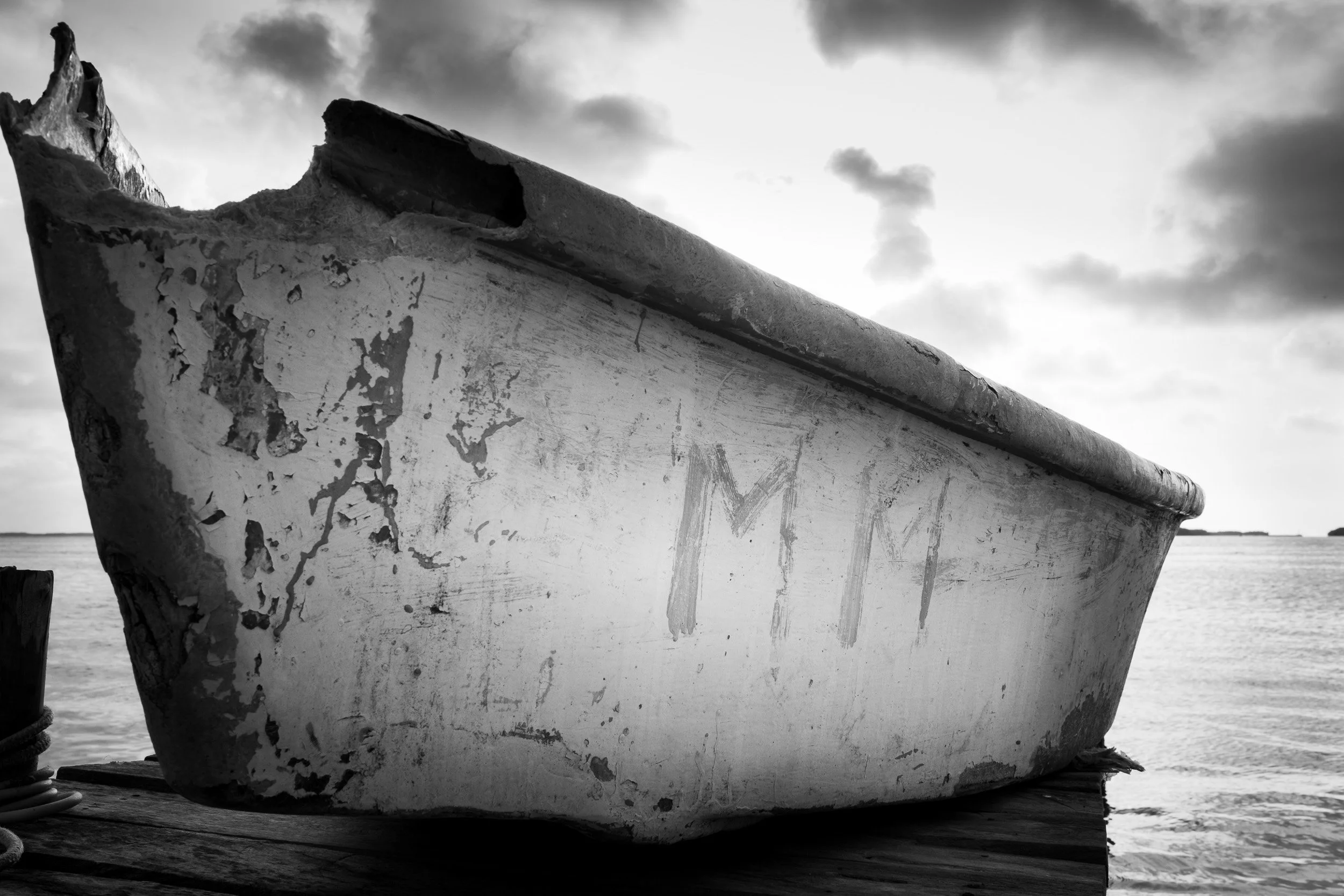 Black and white fine art photograph from From Land to Sea by Tommy (Thomas) Salpietro, depicting a traditional fishing boat in the Yucatán Peninsula, Mexico.