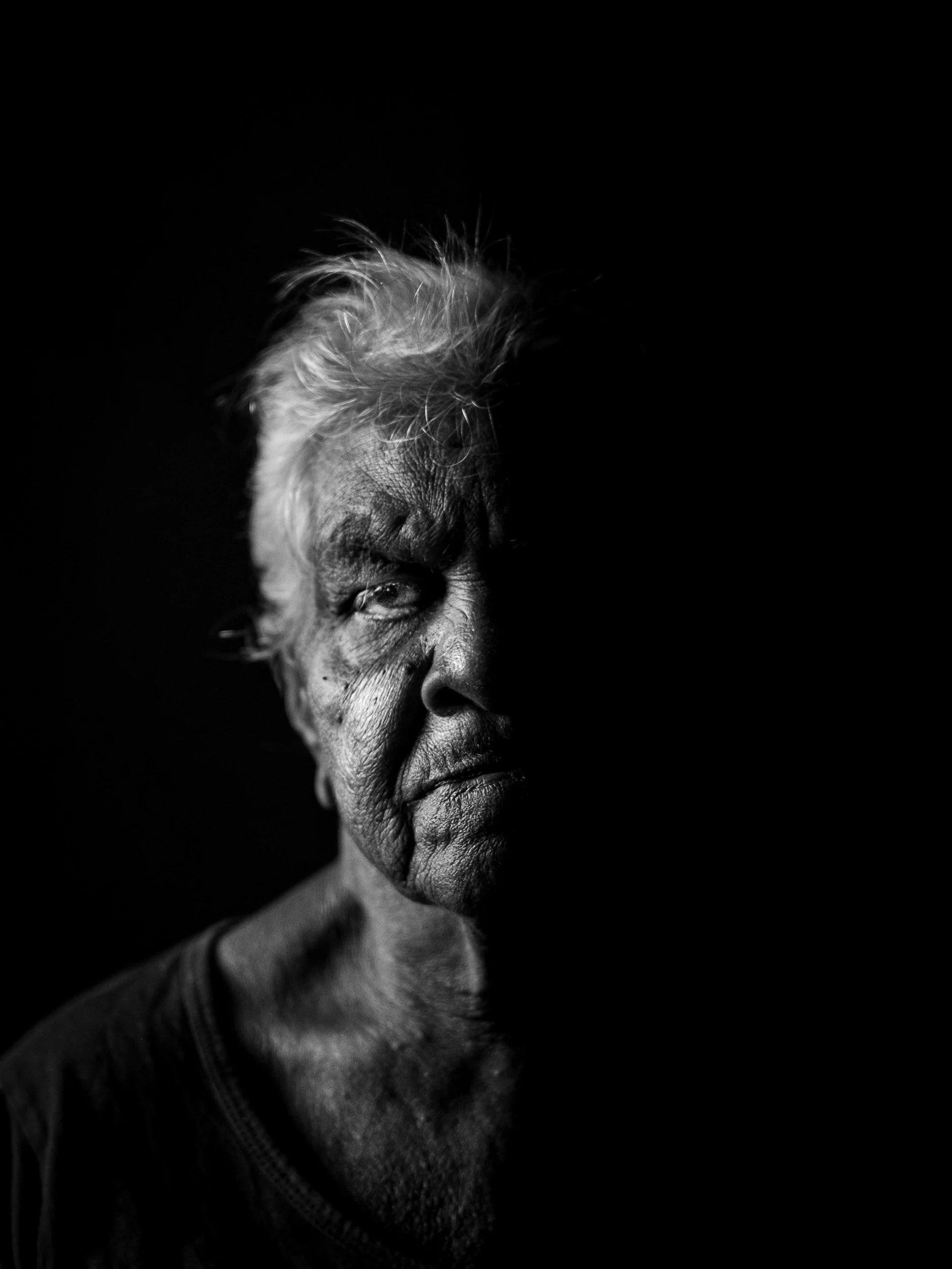 Black and white fine art portrait from From Land to Sea by Tommy (Thomas) Salpietro, depicting a Kuku Yalanji Elder. Documentary photography exploring Indigenous Australian culture, knowledge, tradition and identity.