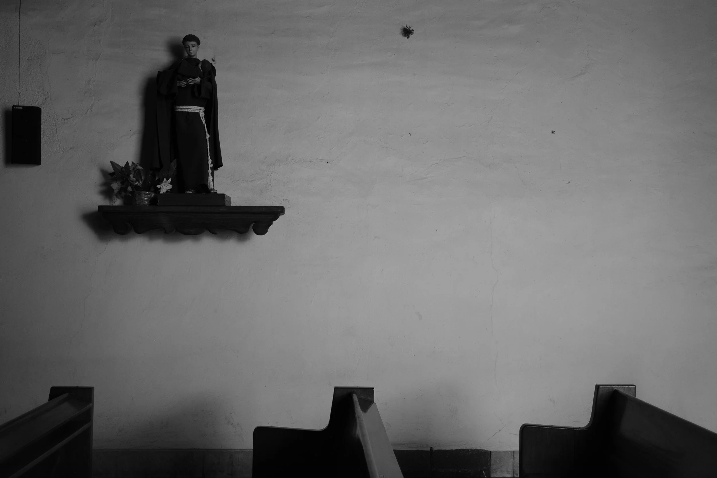 Black and white fine art photograph from Tierra de Silencio by Tommy (Thomas) Salpietro, depicting a Catholic shrine in rural Mexico, exploring faith, devotion and everyday spirituality.