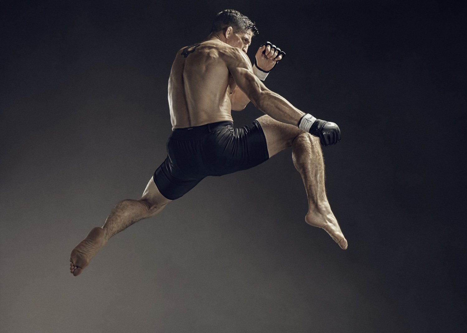 A MMA fighter flys through the air in the sports photography from advertising photographer Jon Enoch