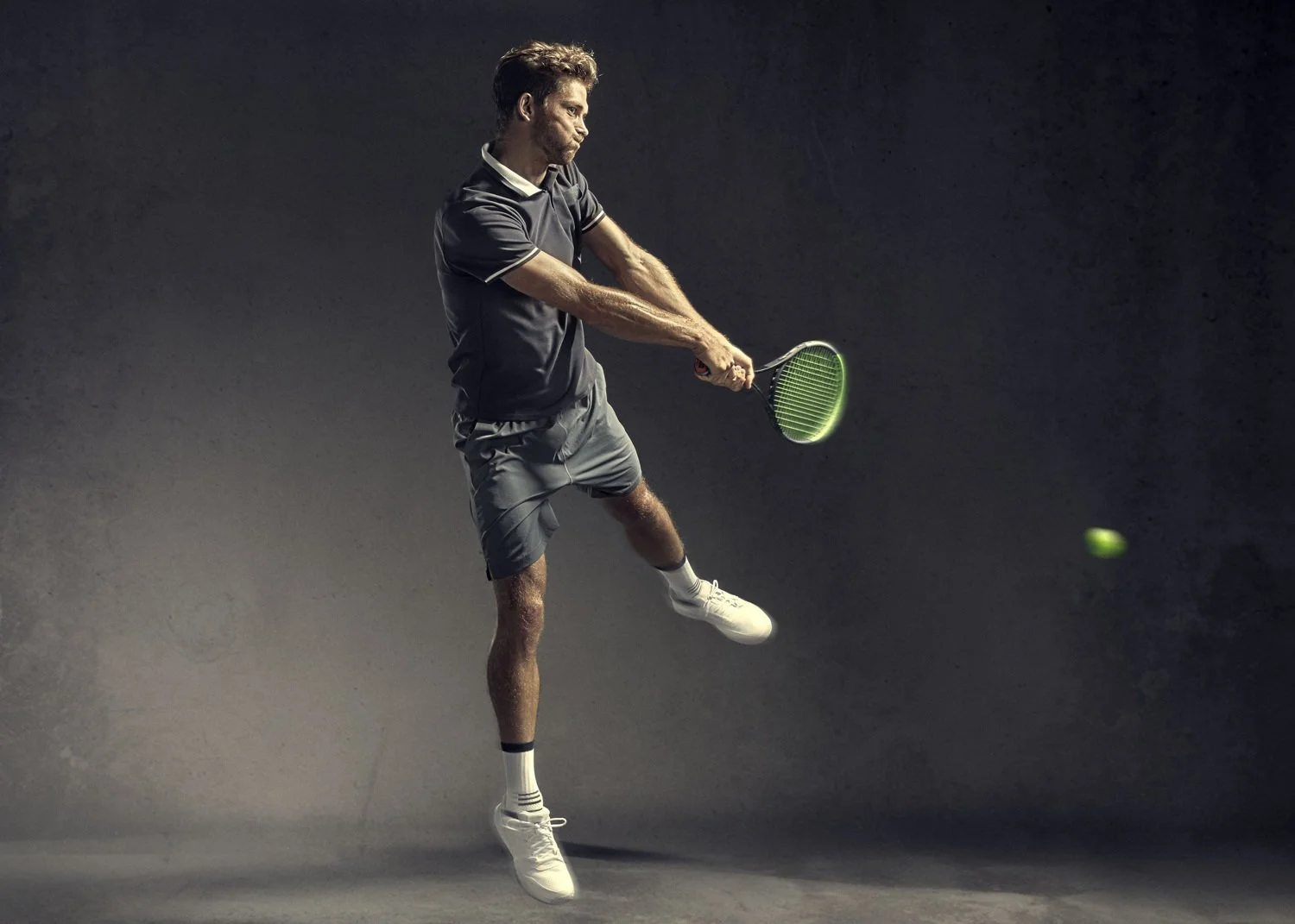 A tennis player smashes the ball in this image by sports photographer Jon Enoch