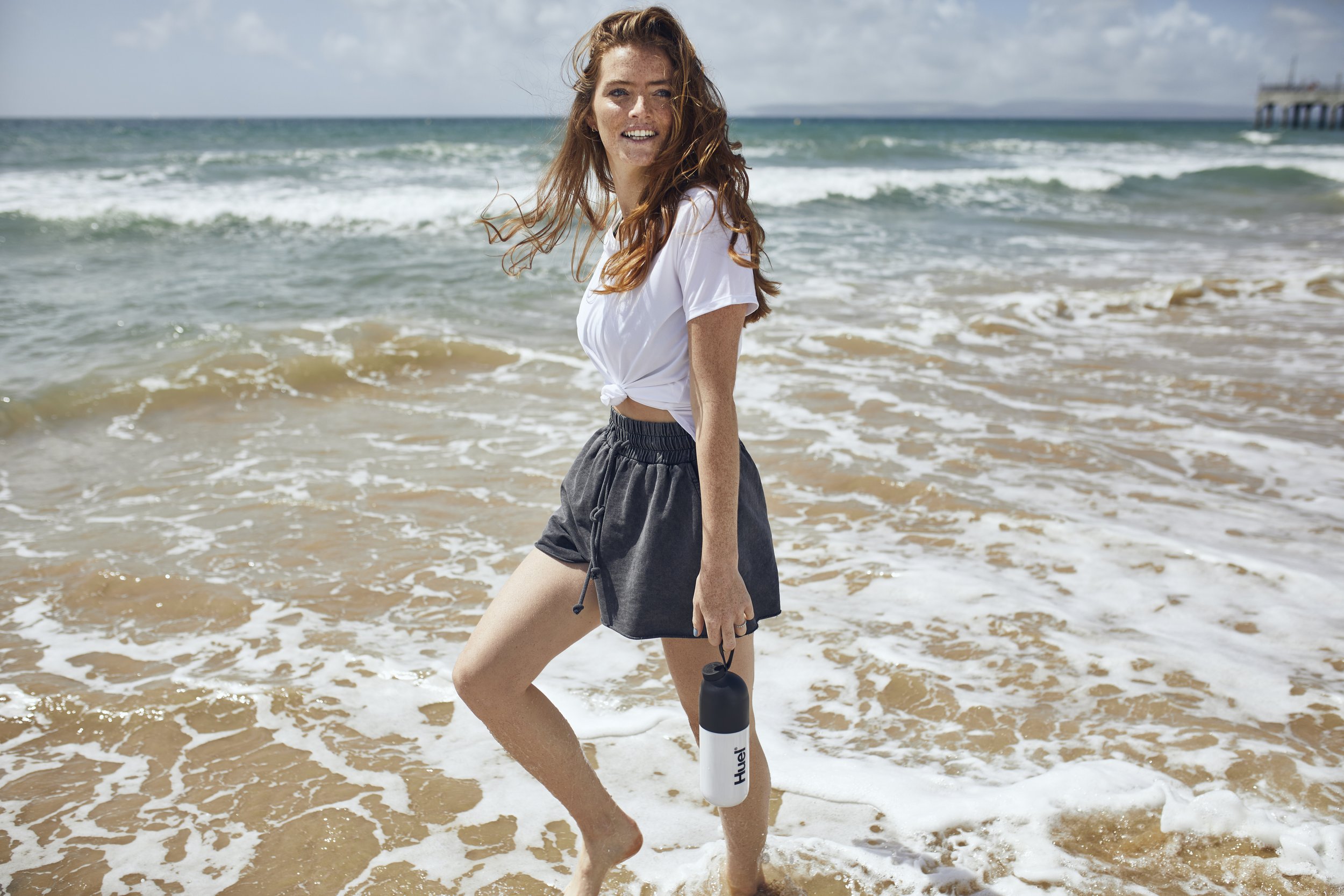 A young women walks in the surf - lifestyle photography by Jon Enoch  (Copy)