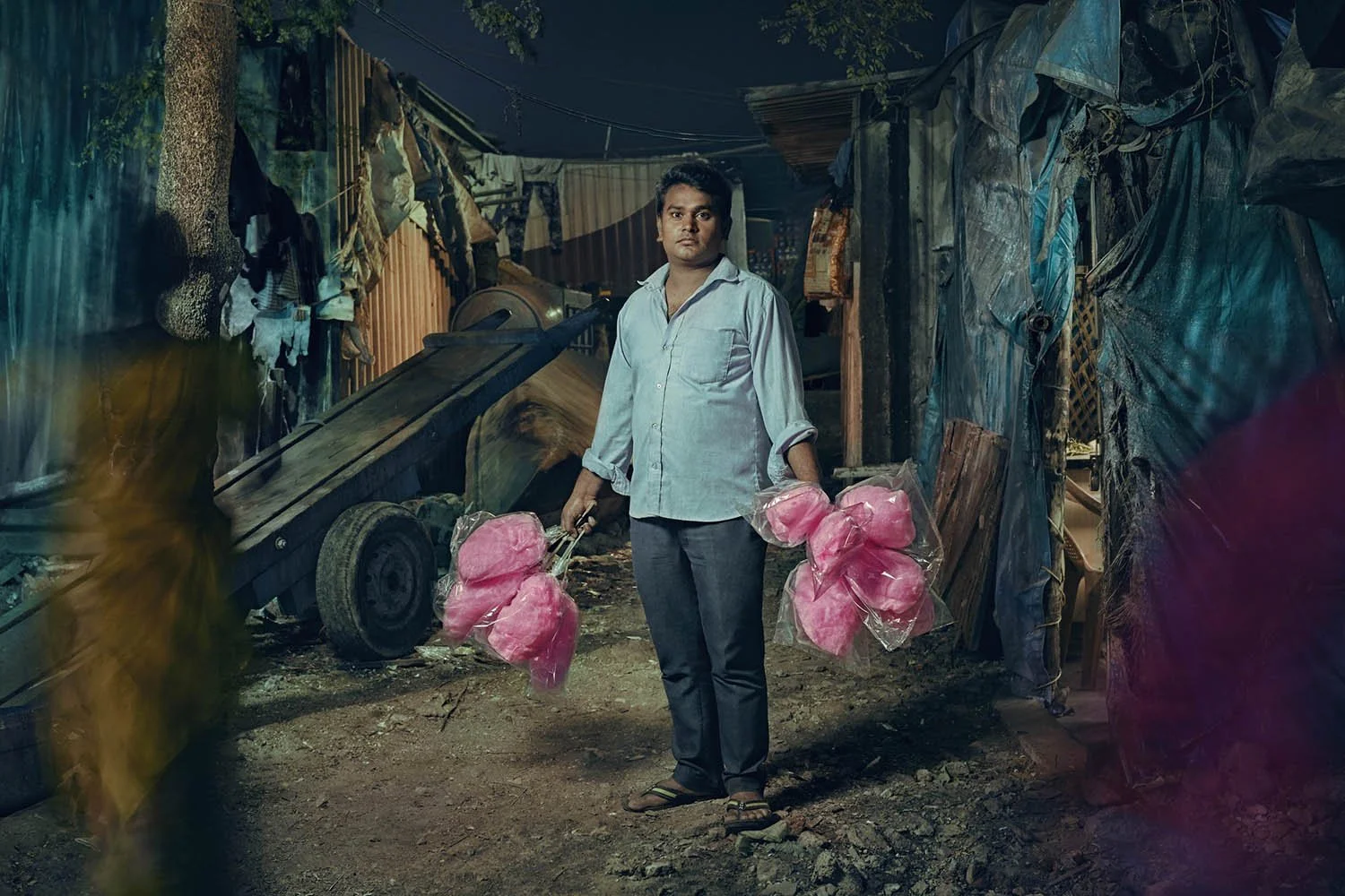 A man sells bright pink candy floss in Mumbai, India. Image taken by lifestyle photographer Jon Enoch.
