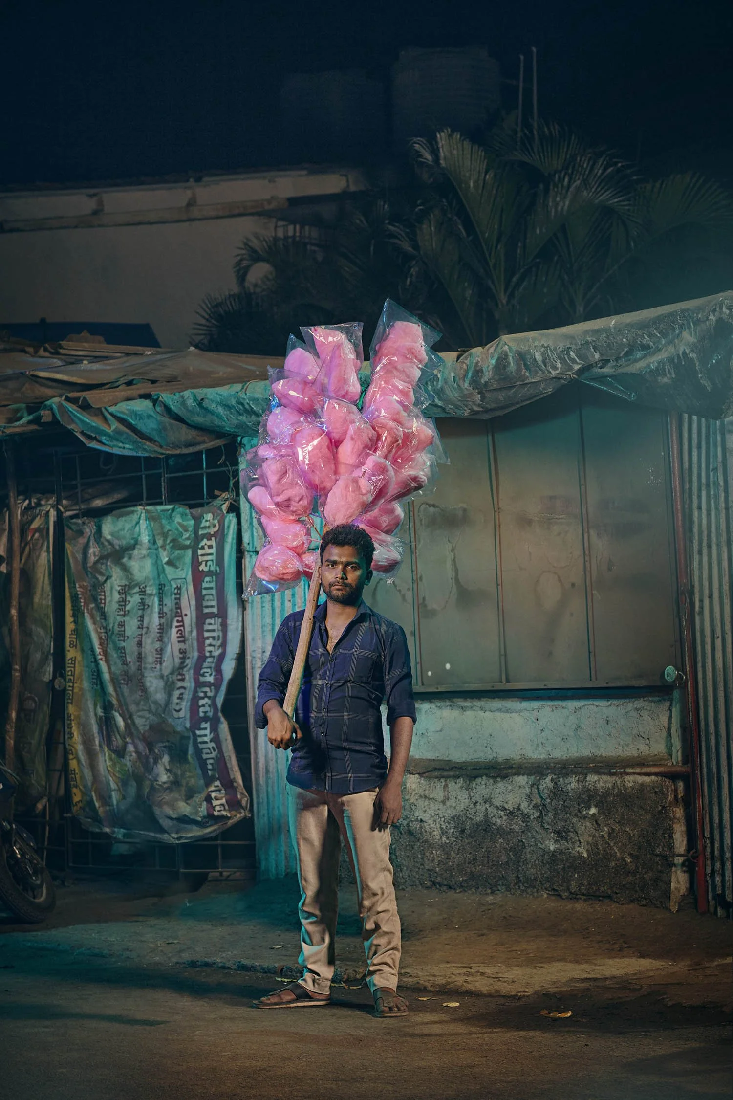 A street vendor sells cotton candy on the street of Mumbai, India. Series by advertising photographer Jon Enoch.