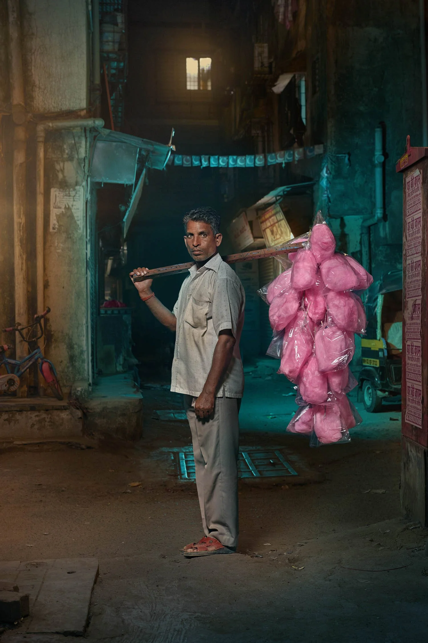 Photographer Jon Enoch captures an image of street vendor selling bags of pink cotton candy in Mumbai, India.