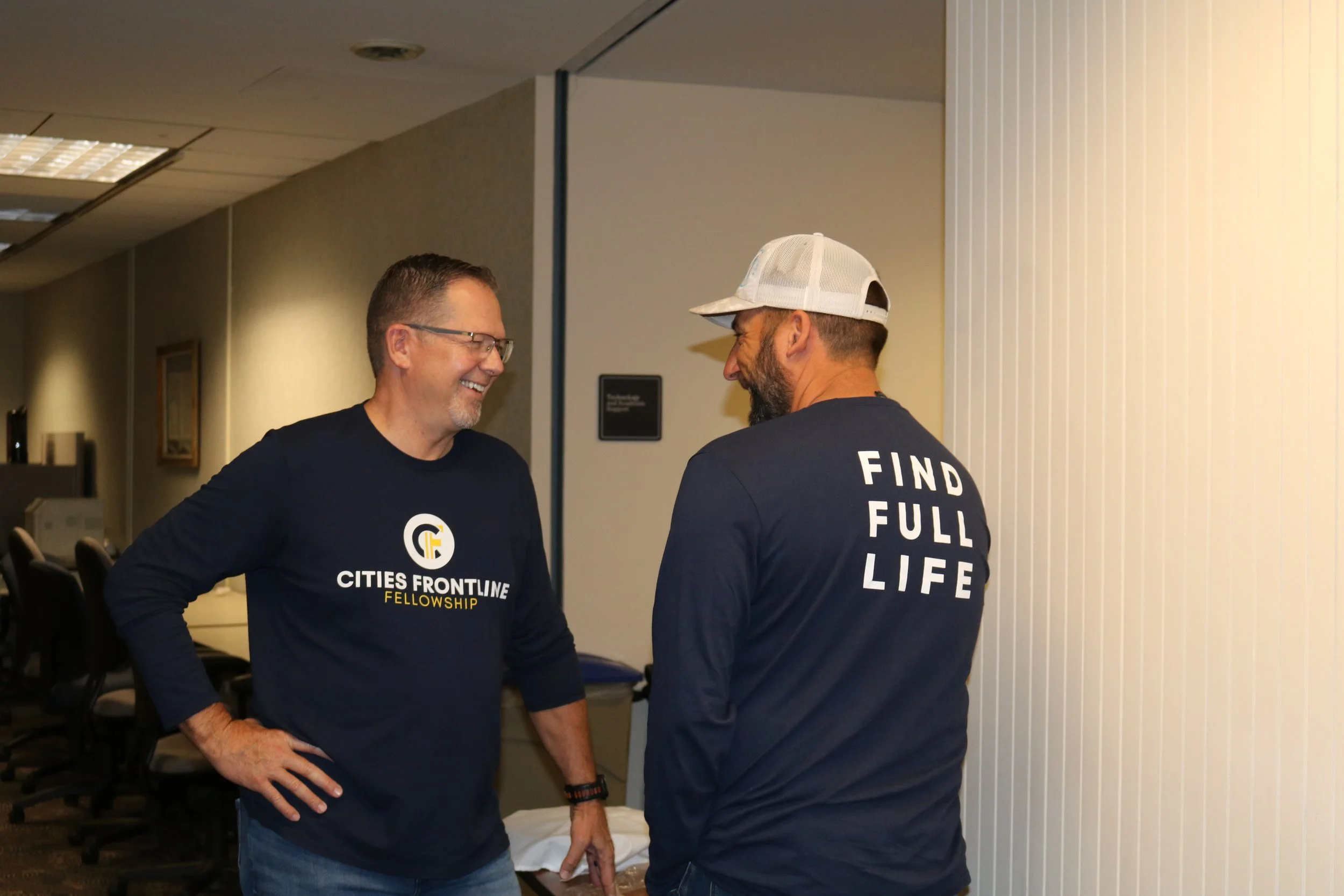Two men wearing dark blue shirts with