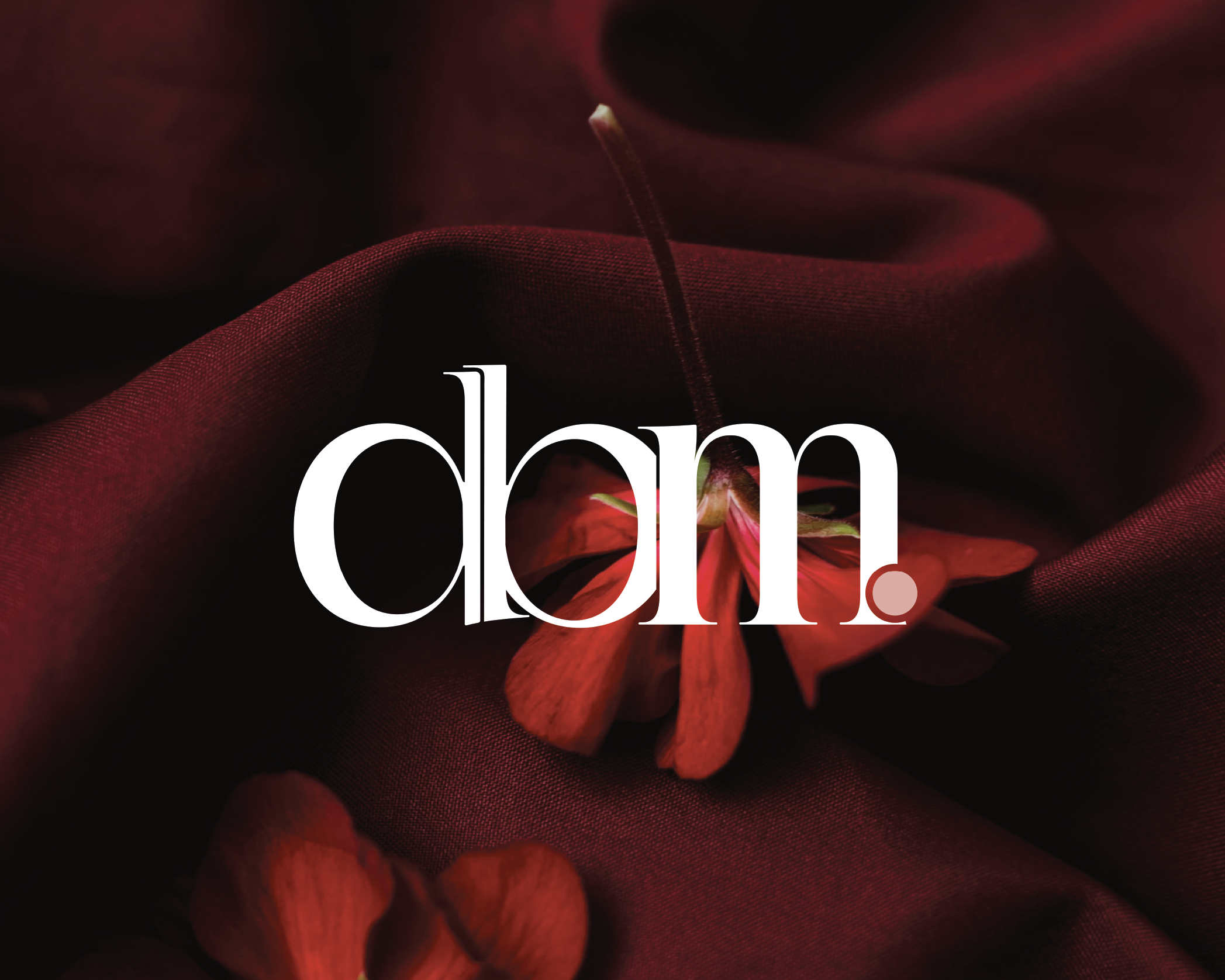 Close-up image of red flower petals with a soft focus and dark background, featuring a Design By Mya logo