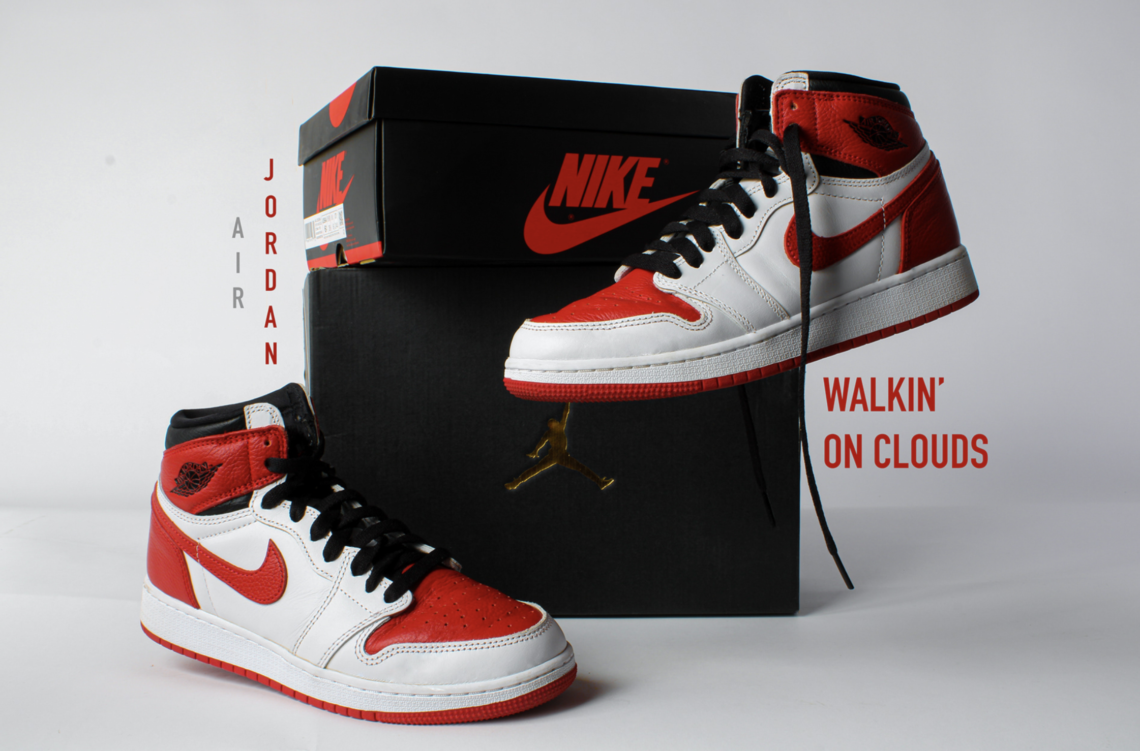 A pair of Air Jordan 1 sneakers in red, white, and black colors placed in front of a black Nike shoes box with a red logo, and some text on the side reading 'Walking on clouds.'