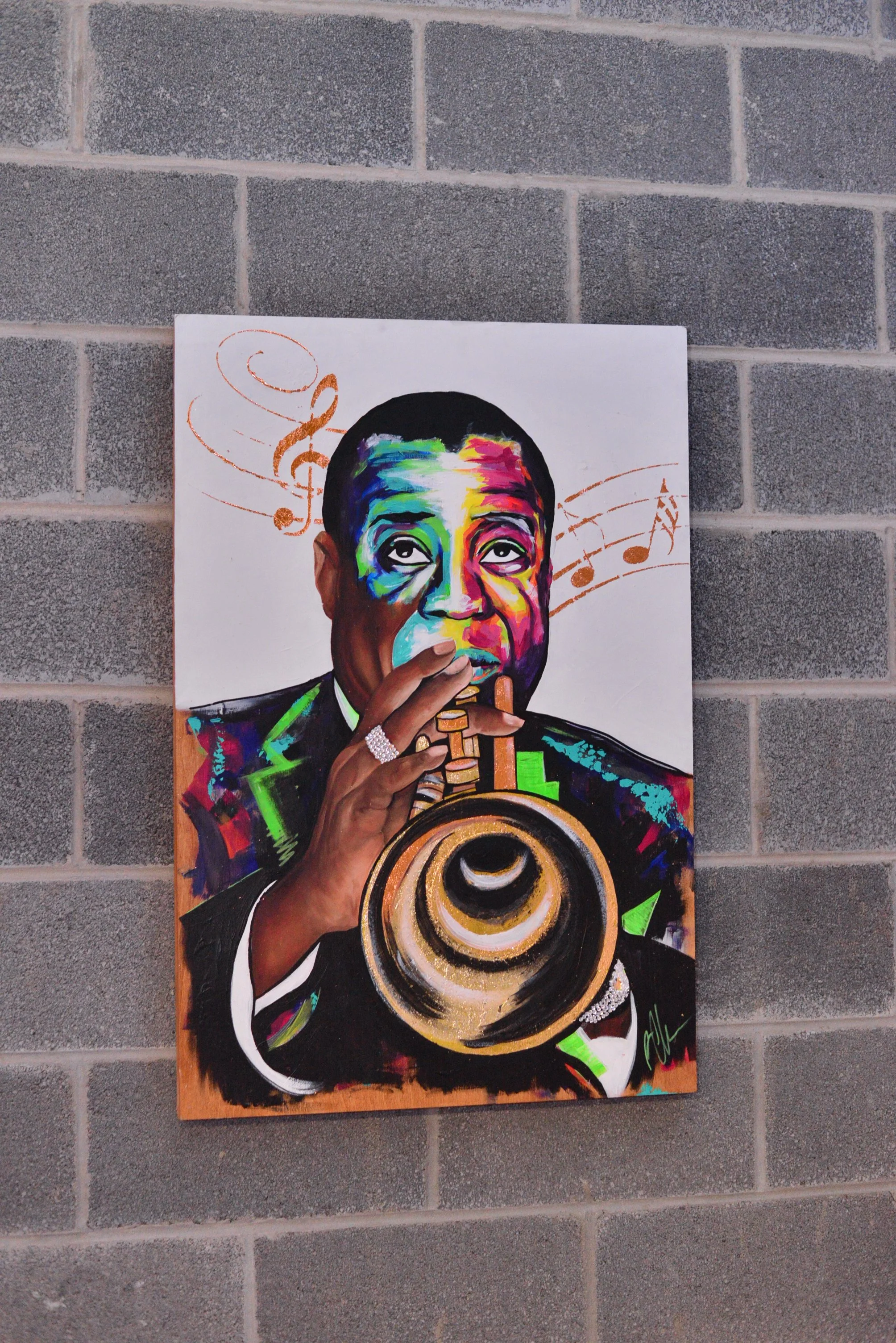 Colorful painting of a man playing a trumpet, with musical notes swirling around his head, mounted on a brick wall.