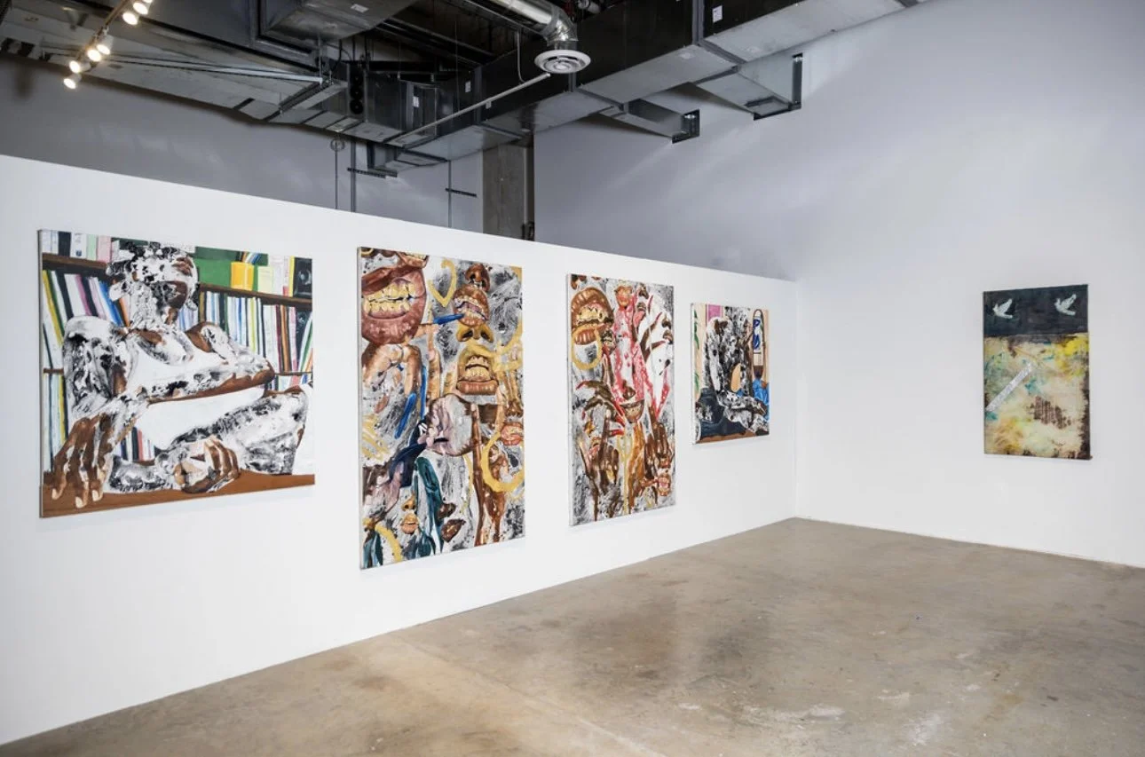 Gallery with five large abstract paintings on a white wall, featuring colorful, chaotic imagery including distorted faces and textured backgrounds, in a modern art exhibition space.