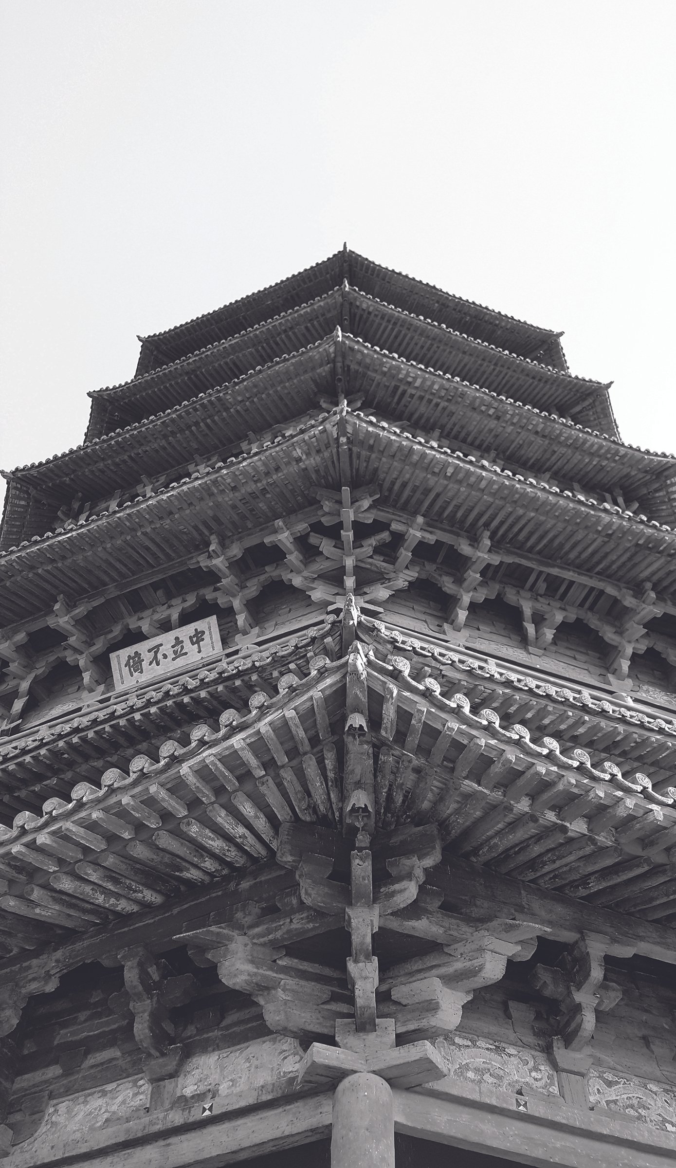 A traditional Japanese multi-tiered pagoda with intricate woodwork and curved rooflines, viewed from the front.