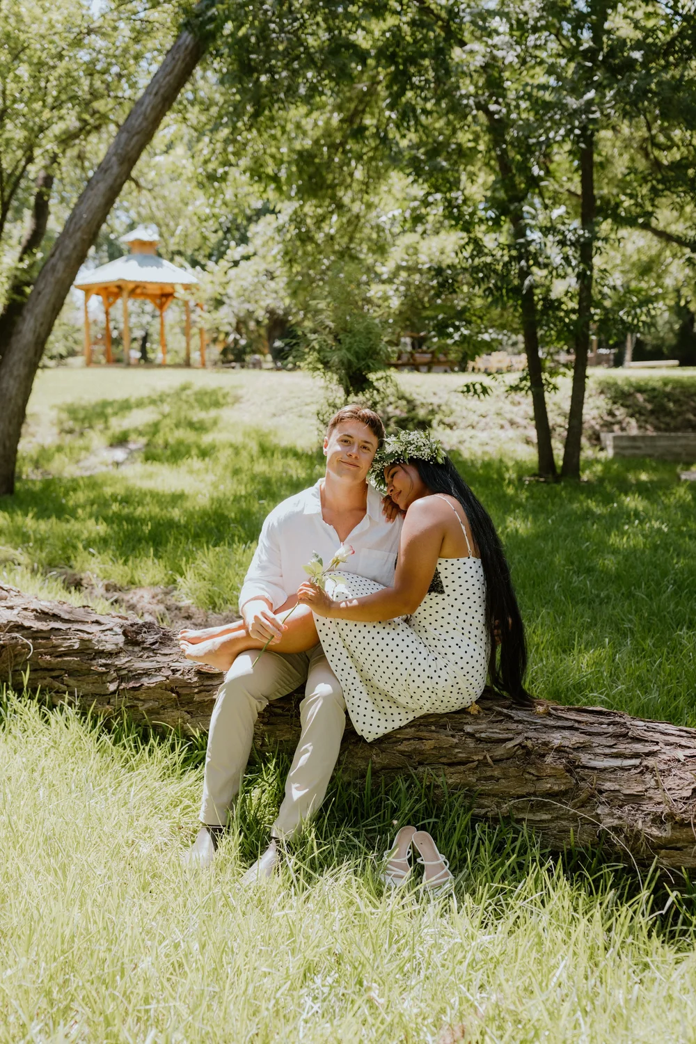 Del Rio, Texas couples photographer: a couple sitting on a fallen log in the park