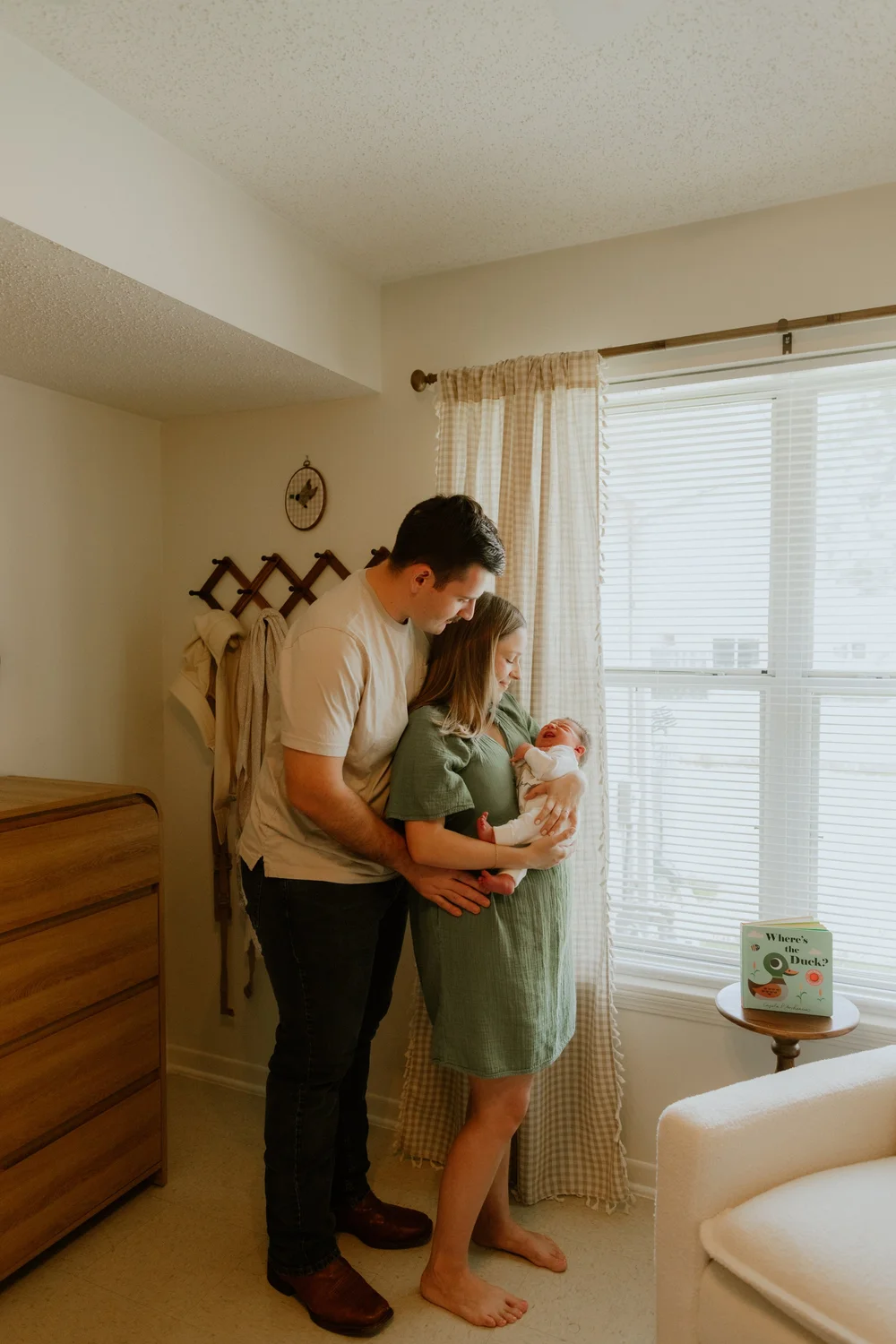 A family holding their newborn by the nursery window in Del Rio, Texas