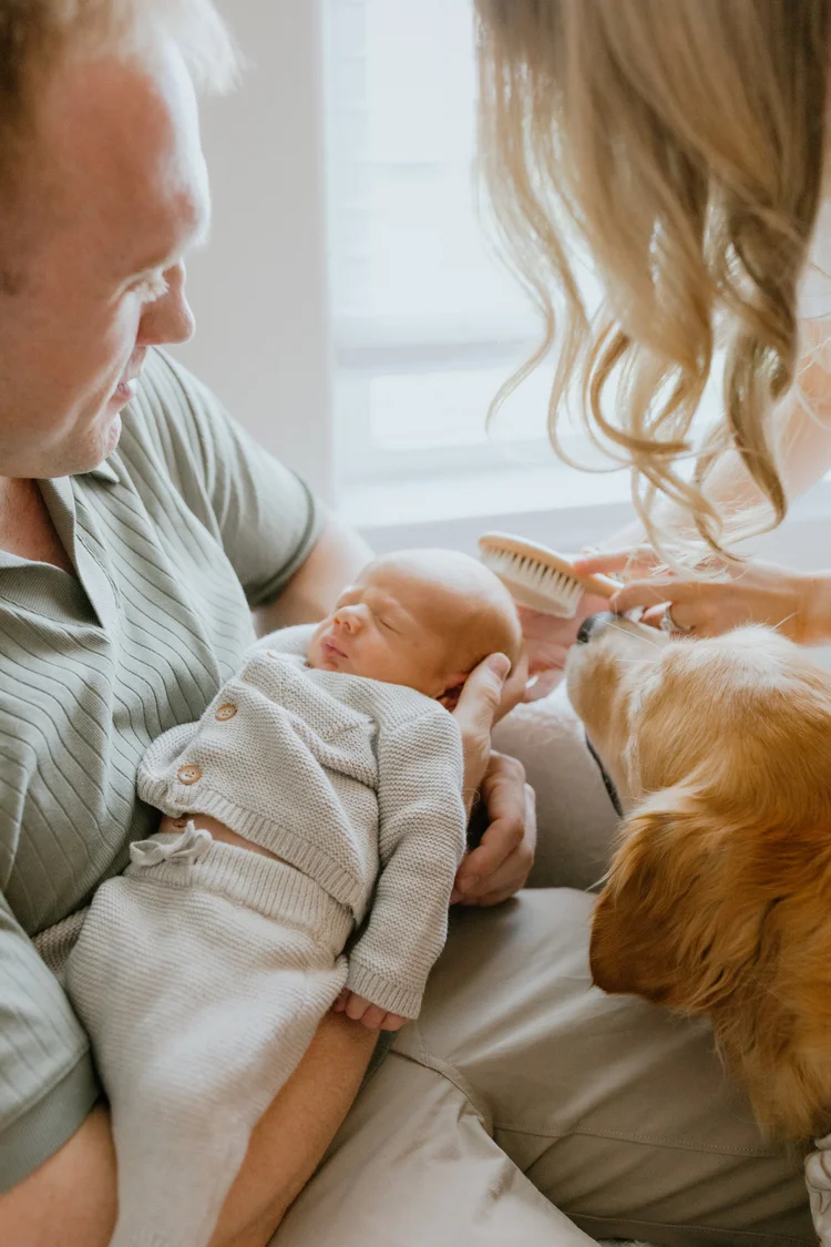 Del Rio, Texas family photographer: a father cradles his newborn while the family dog looks on