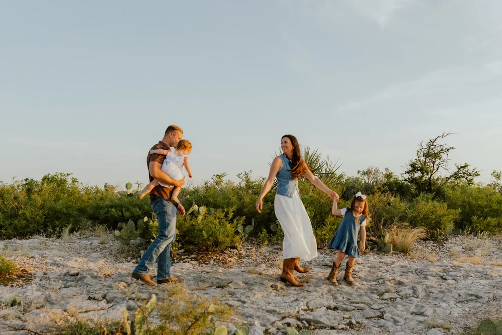 A family walking hand in hand across the rocky desert near Del Rio, Texas