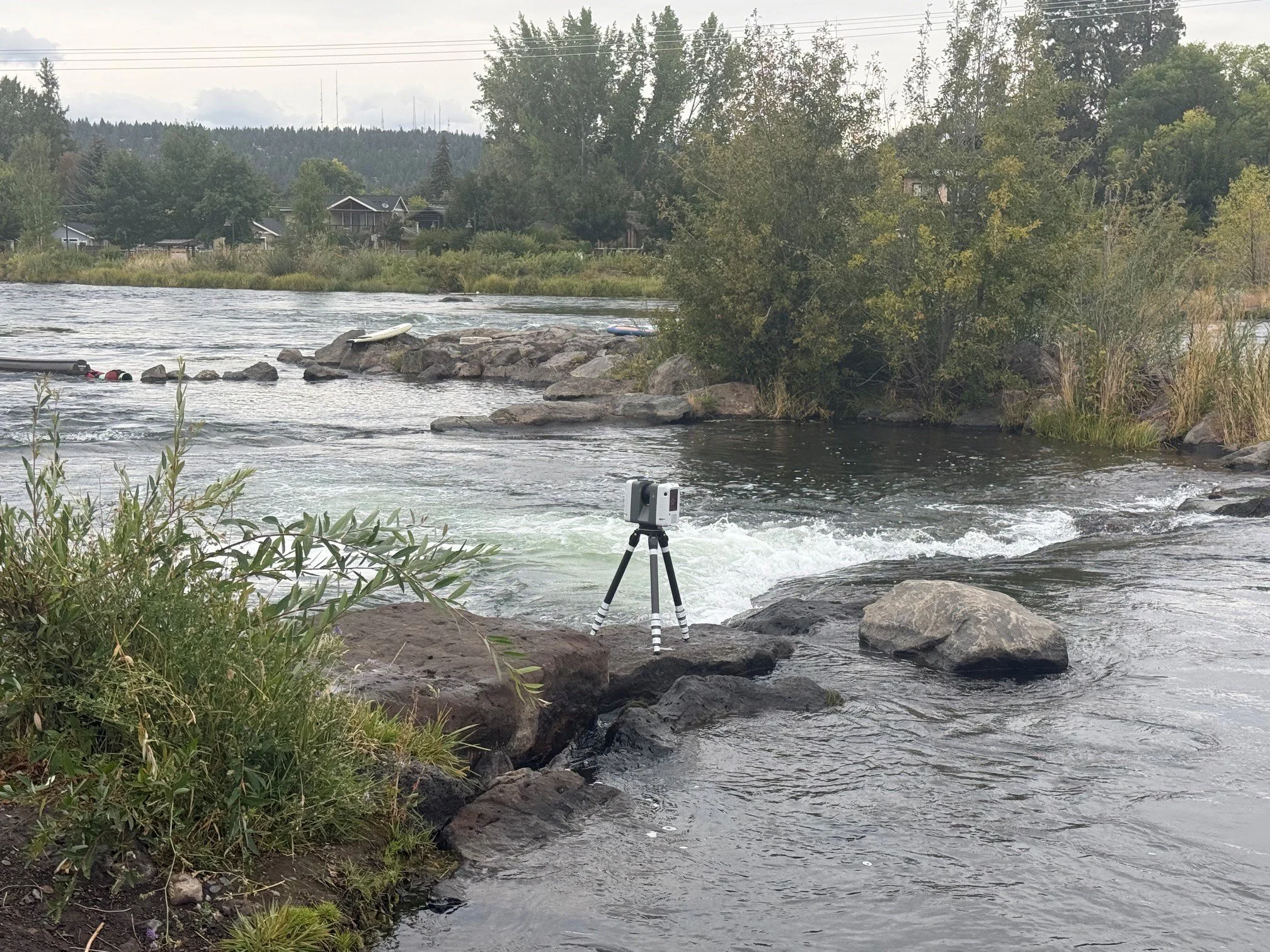 Leica laser scanner on a tripod capturing the Deschutes River rapids at McKay Park in Bend, Oregon