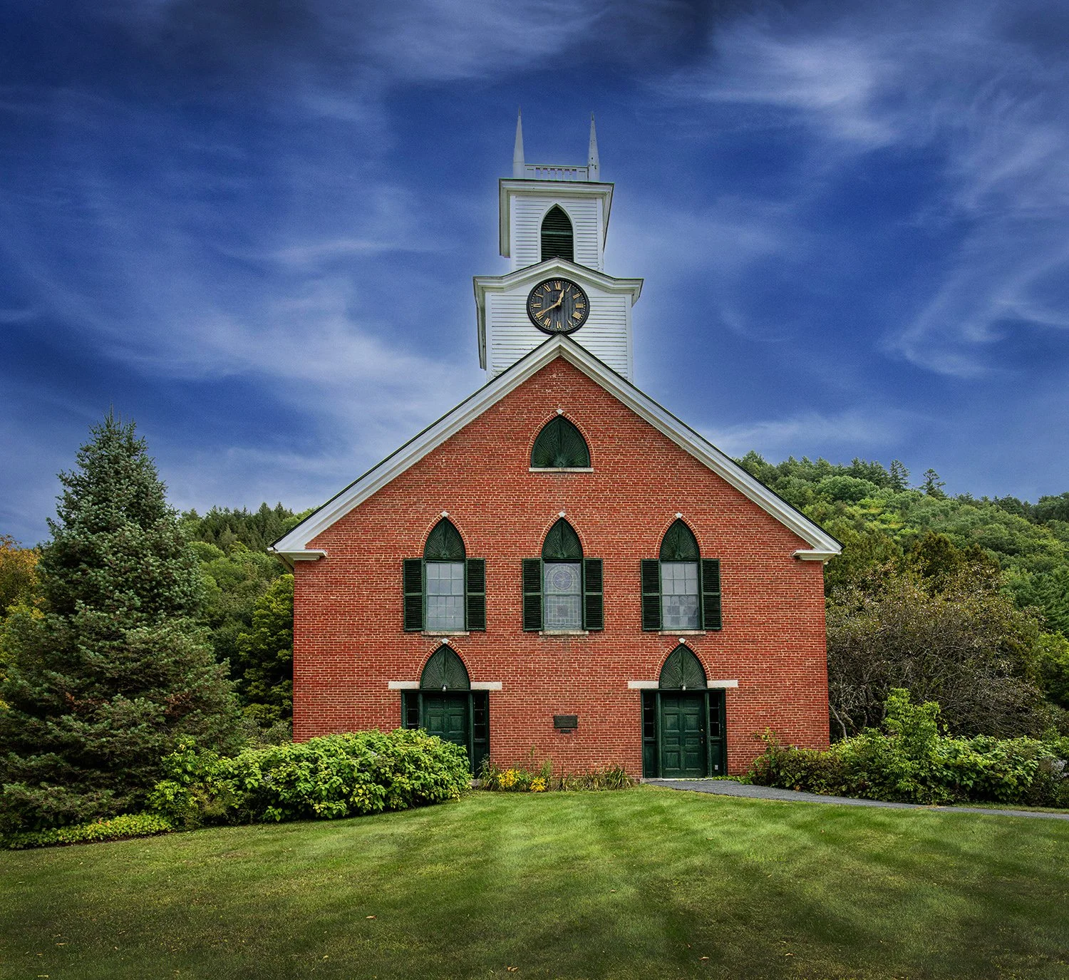 Front view of a the Frost Center church building with its beautiful red brick, green doors and black shutters