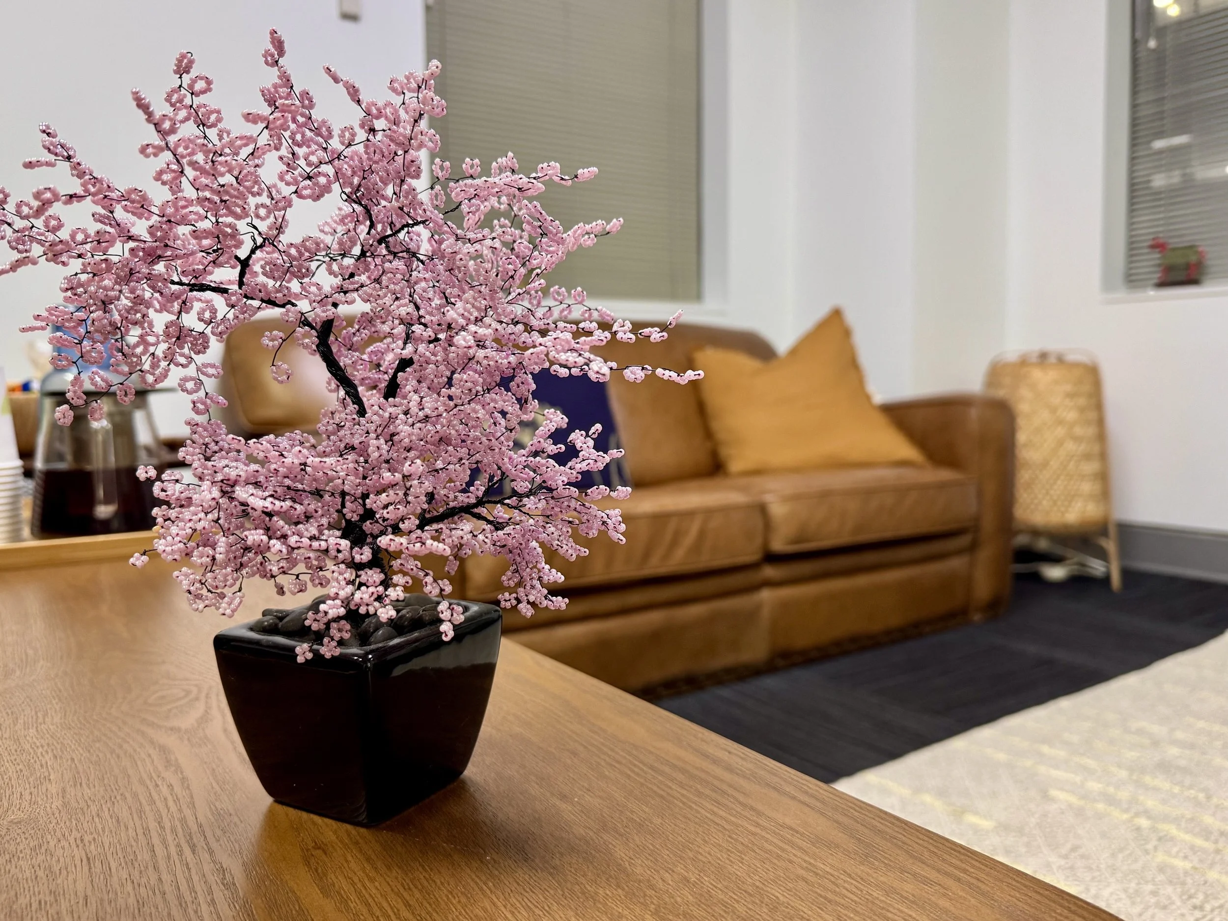 Pink beaded cherry blossom tree with the consulting room sofa in the background.