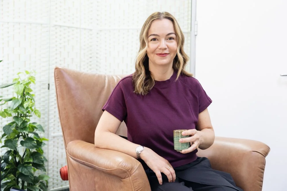 Clinical psychologist Irina Petrova seated in a brown armchair in her North Sydney consulting room.