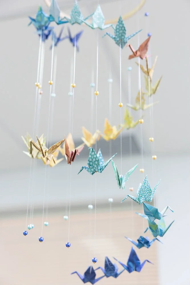 Colourful paper crane mobile hanging in the consulting room.