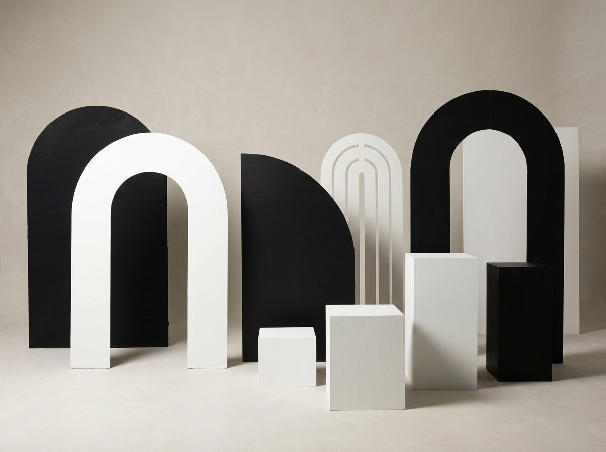 Various black and white decorative arch-shaped and rectangular blocks arranged in a pattern on a plain wall background.