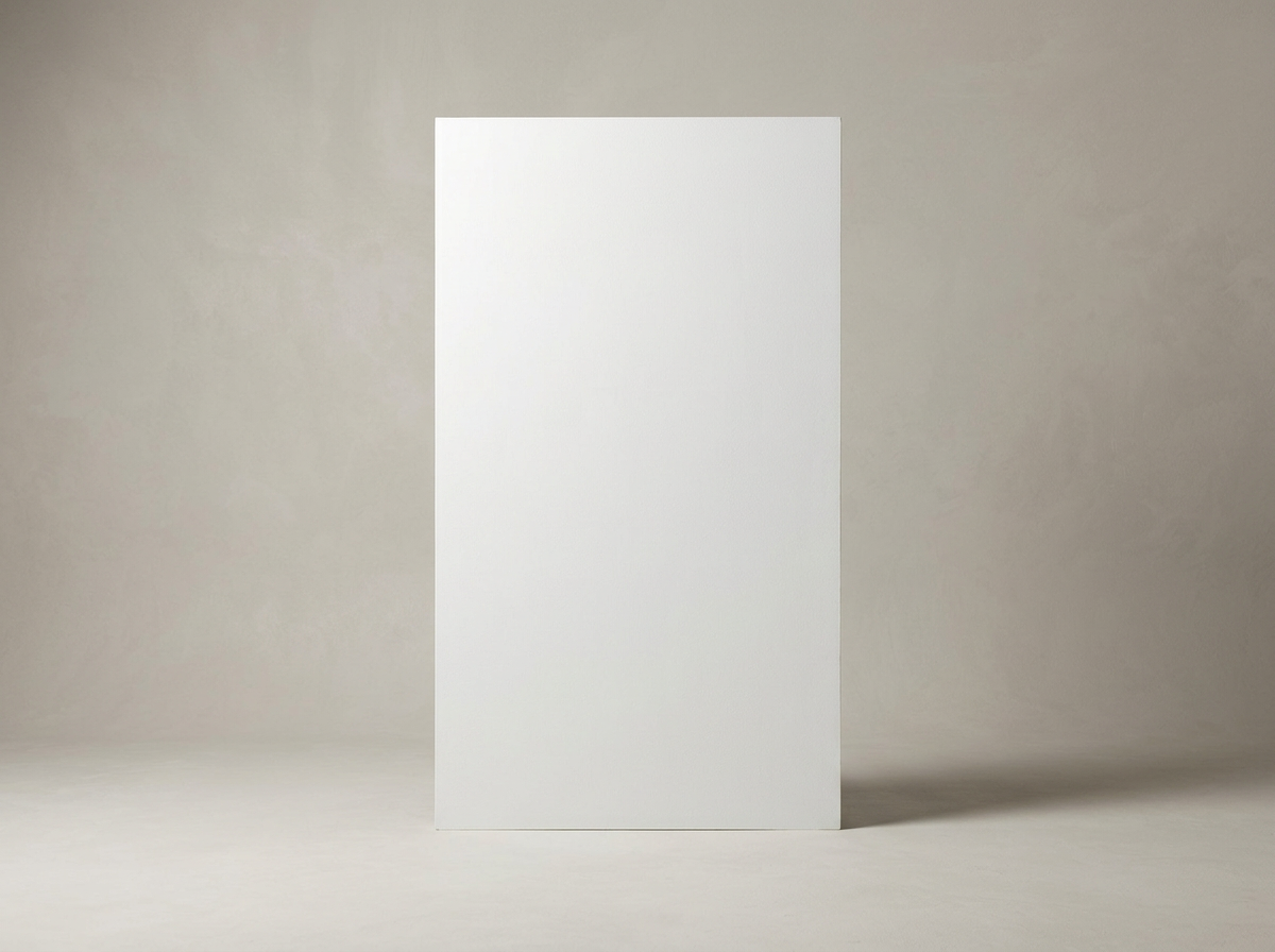 A plain white rectangular board standing upright in a neutral, light gray room.