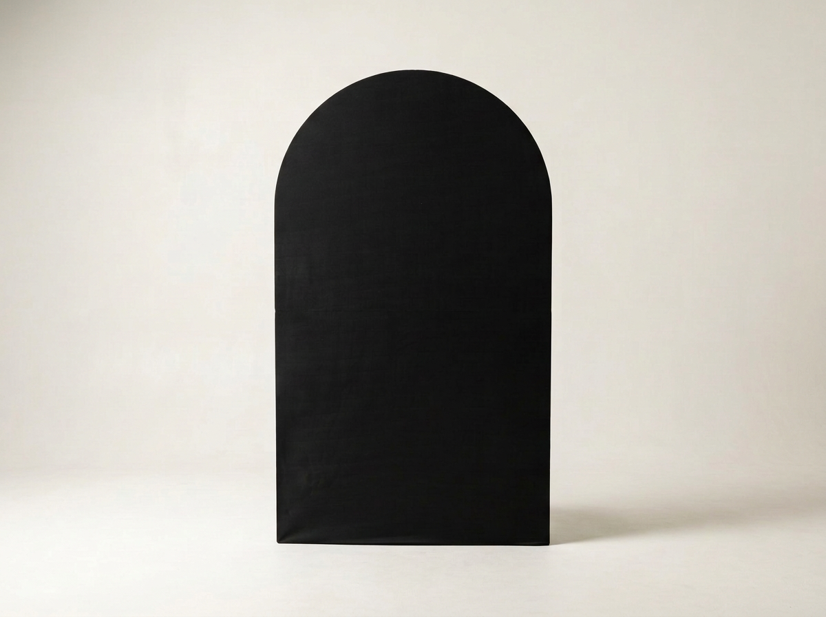 A black arched paper bag or box with no handles placed on a white surface against a white background.
