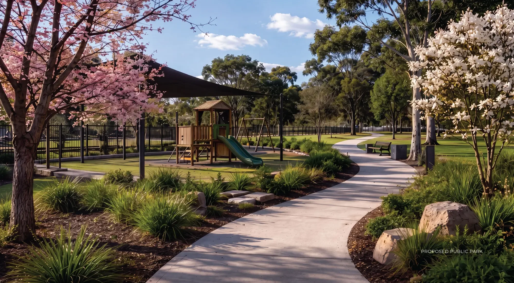 A park with a playground, cherry blossom trees, and a winding concrete pathway. The park has a shade structure over part of the play area, lush green grass, and trees in the background. Clear blue sky with a few clouds.