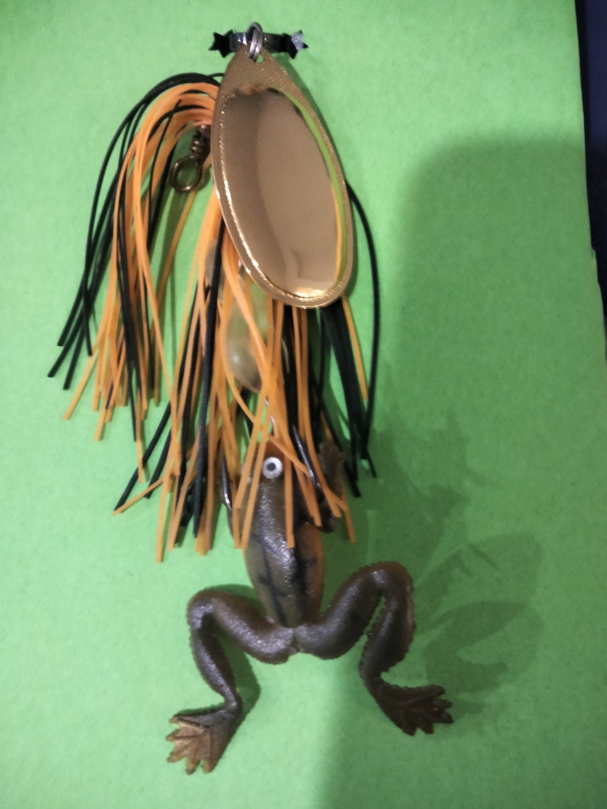 A sculpture of a lion with a mirror on its back, standing on a green surface against a green background.