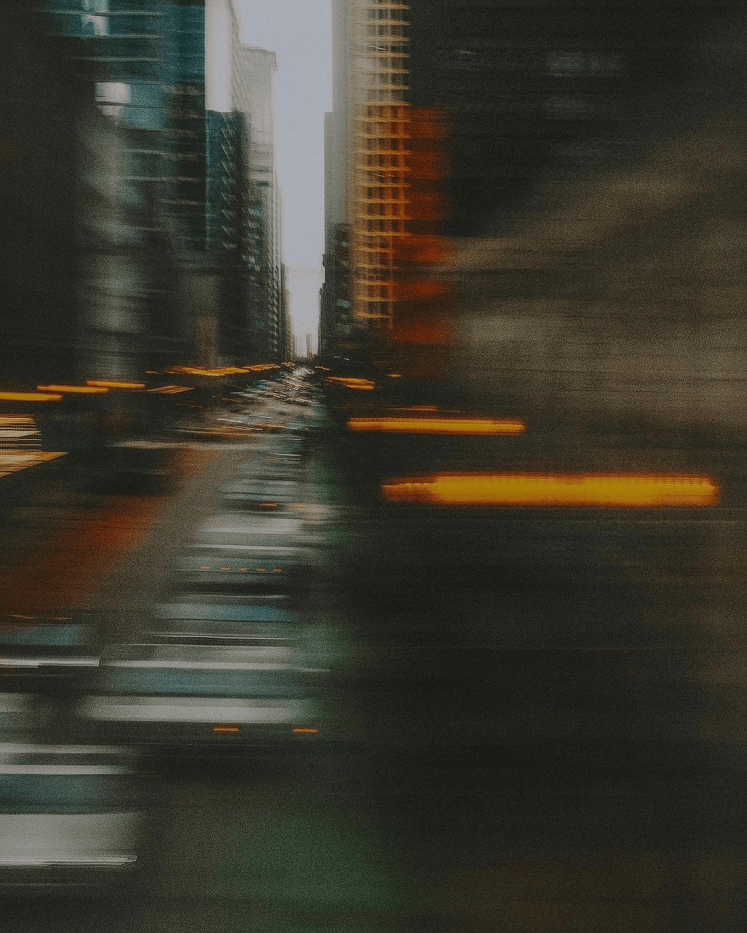 Blurred city street scene with tall buildings and car lights