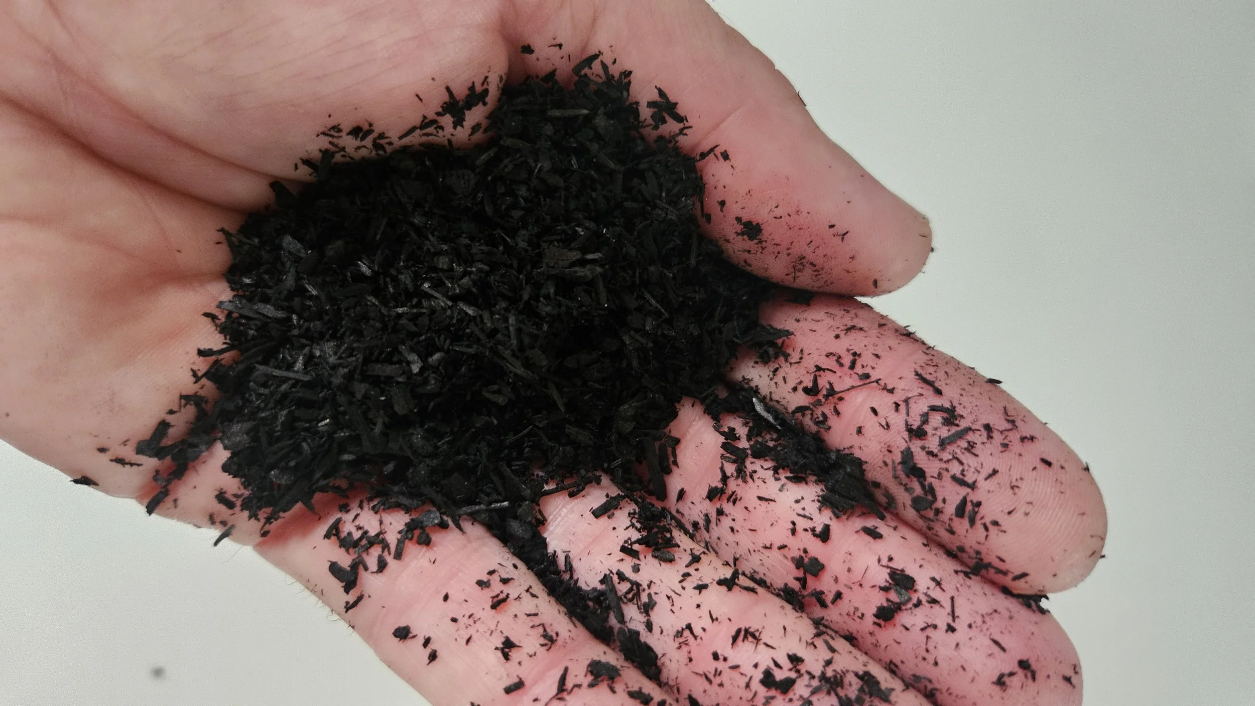 A hand with black particles, possibly charcoal or ash, spread across the fingers and palm.