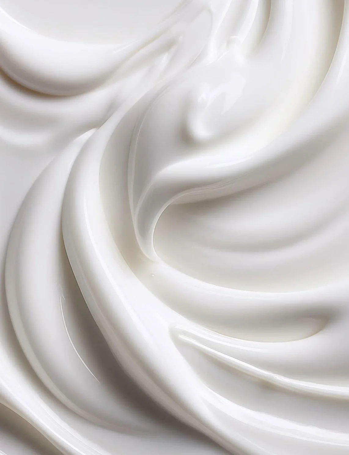 Close-up of smooth, creamy white whipped cream swirled into soft peaks.