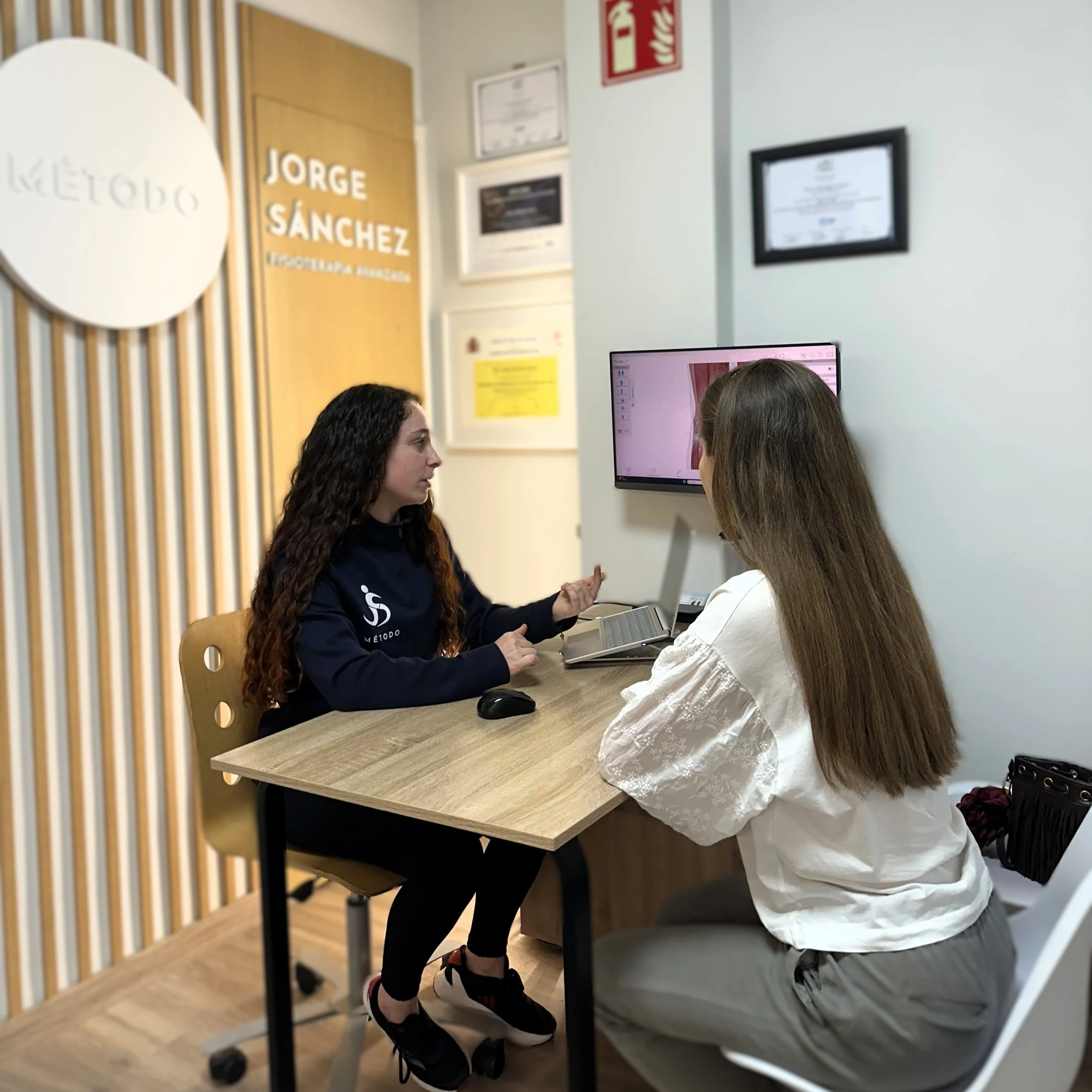 Fisioterapeuta explicando en tratmaiento en una sesion de valoracion inicial en la consulta Método Jorge Sánchez.
