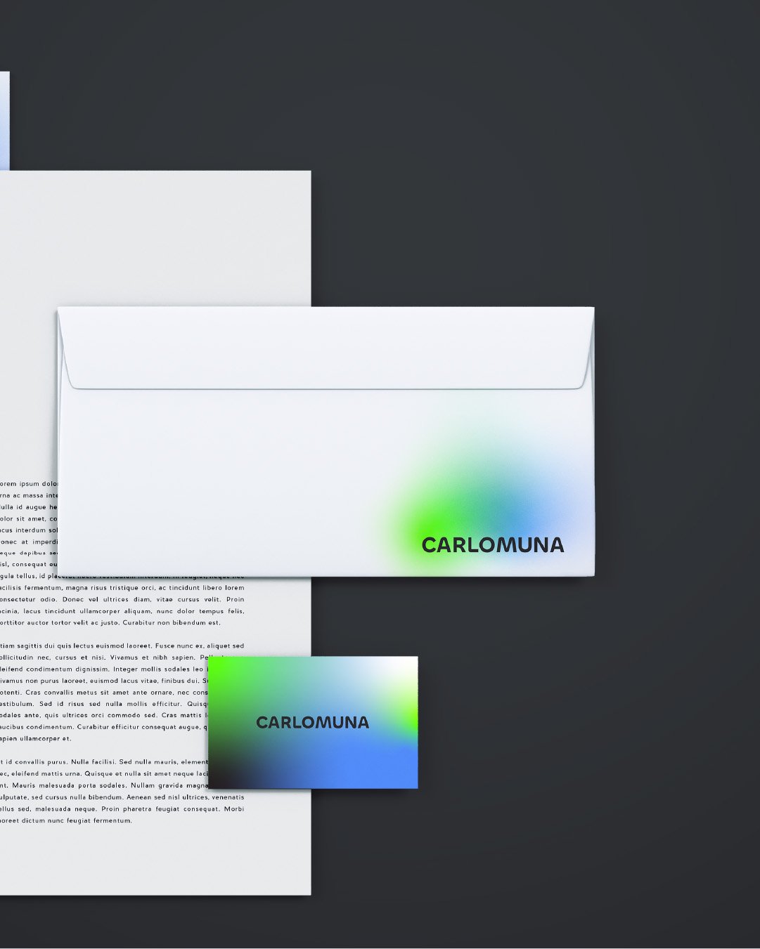 Una busta bianca con il logo 'CARLO MUNA' a colori e un foglio di carta bianco, posti su una superficie scura. Sulla busta c'è anche un'illustrazione colorata che riproduce i colori verde, blu e bianco.