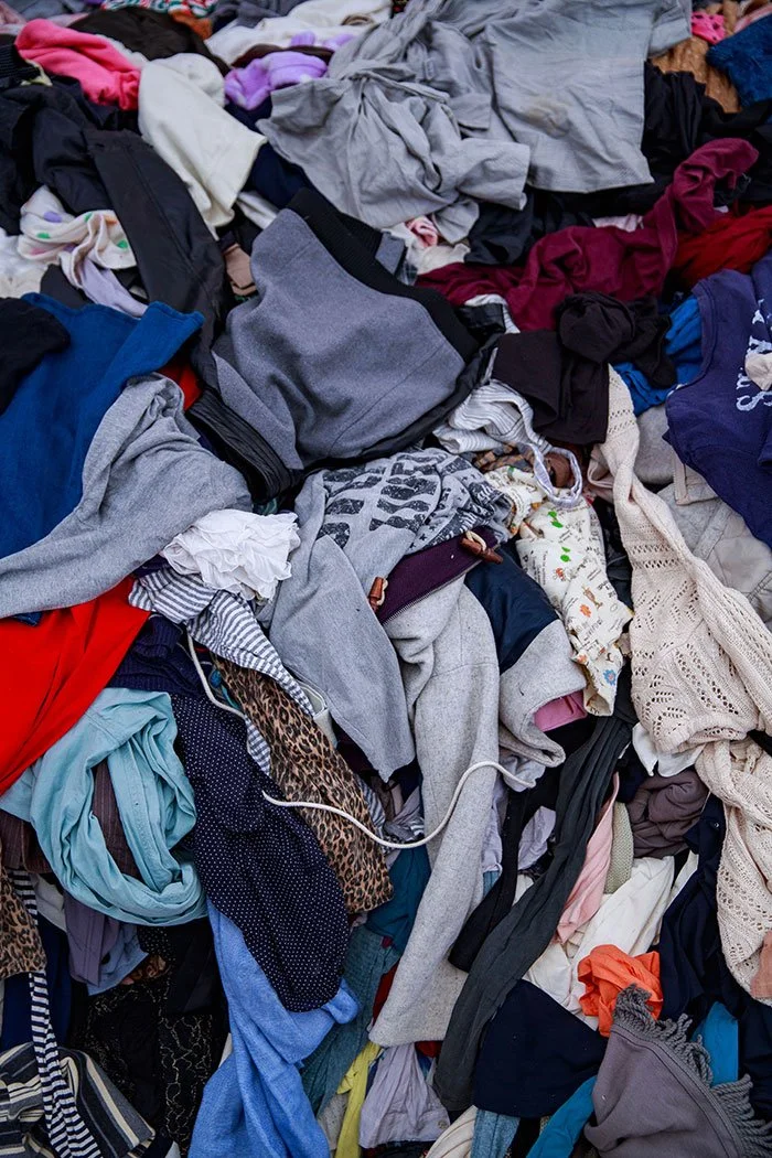 Pile of assorted laundry clothes and textiles in various colors and fabrics.